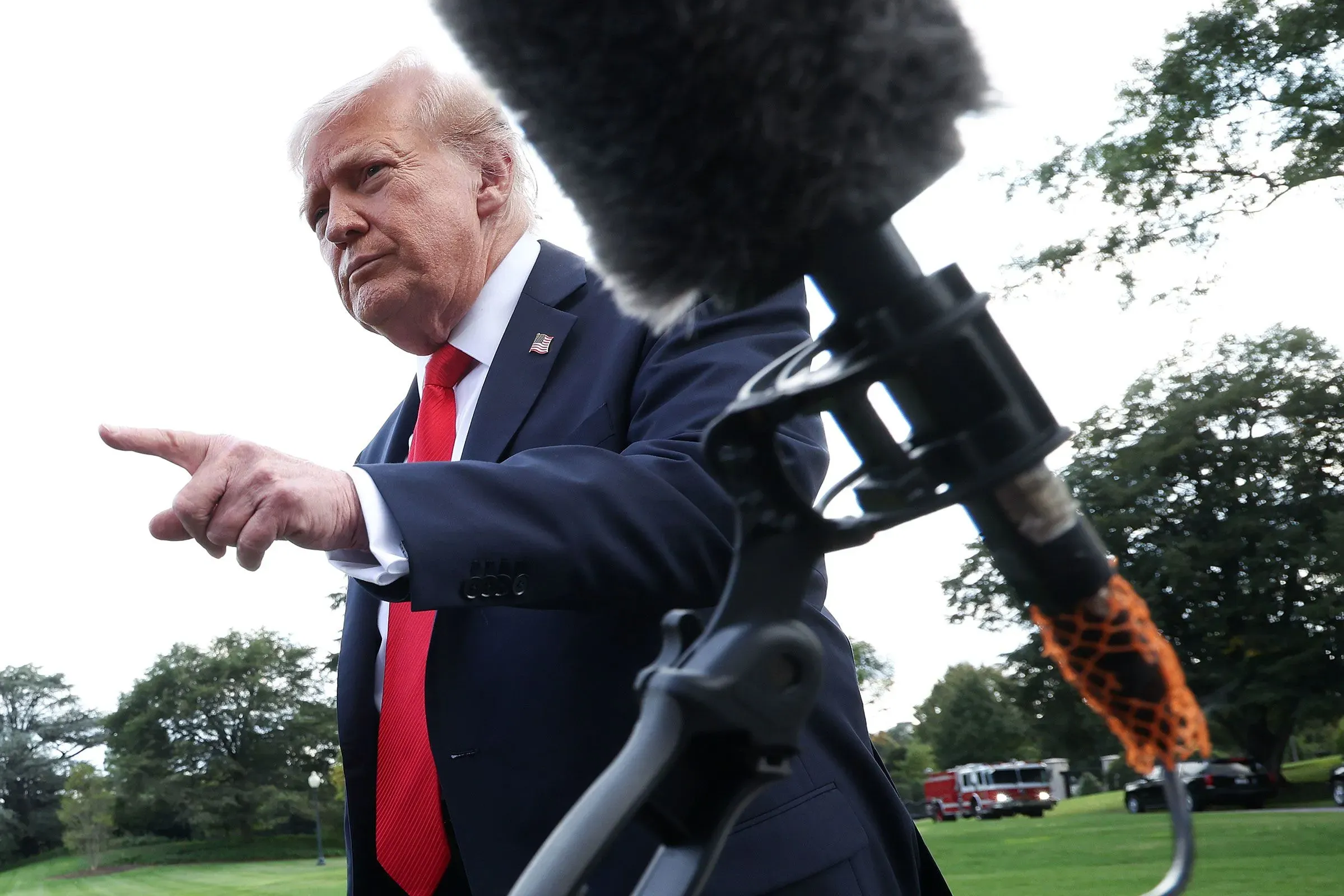 ترامب يشير بإصبعه أثناء حديثه، مع ميكروفون قريب، في سياق تعليقه على وفاة روب راينر وزوجته.