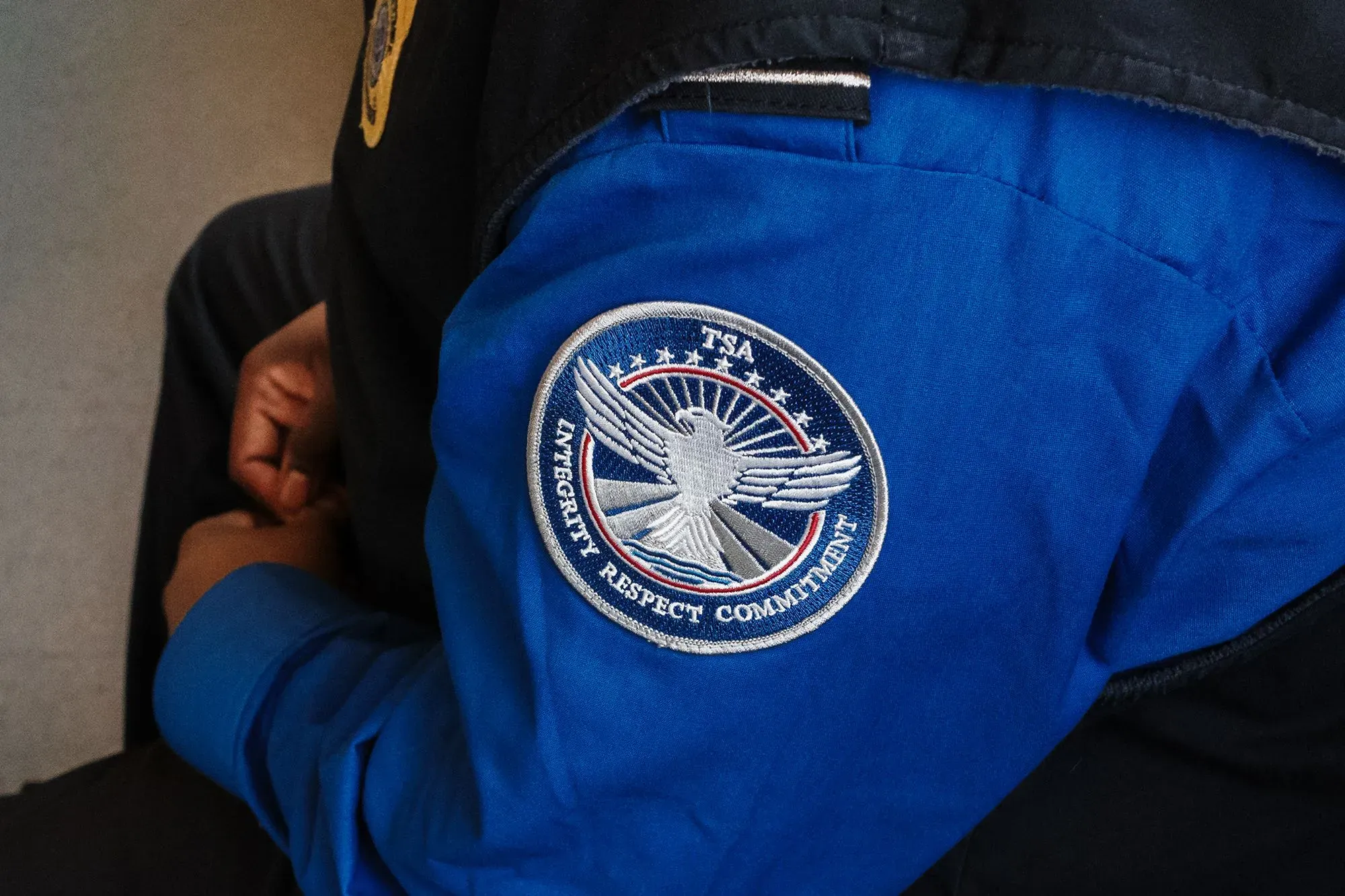 شعار إدارة أمن النقل (TSA) على زي أحد الموظفين، يعكس التوتر والقلق بسبب تأخر الرواتب خلال الإغلاق الحكومي.