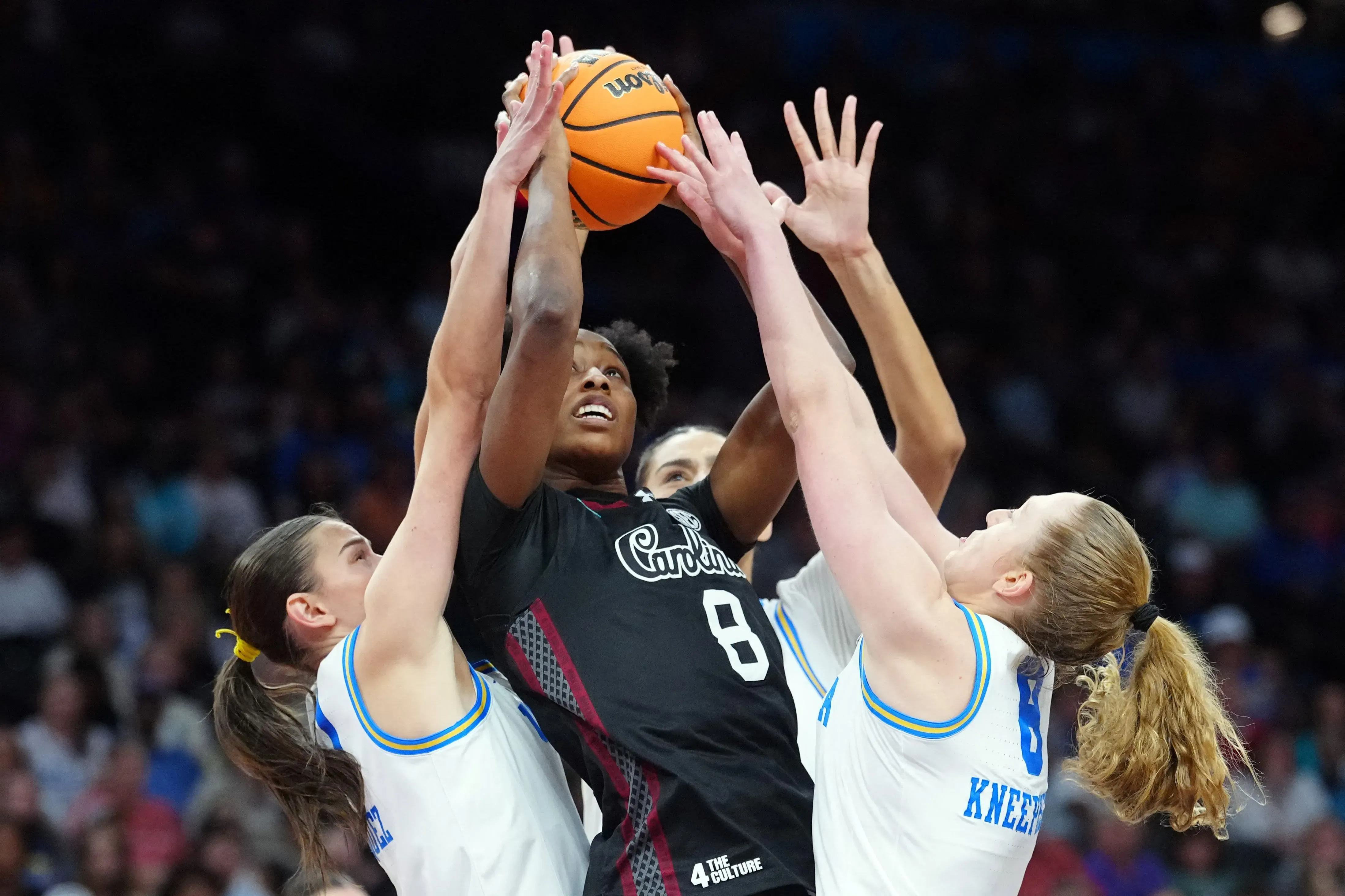 لاعبة كرة سلة تحاول تسجيل نقطة وسط ضغط من لاعبتين من فريق منافس، خلال مباراة نهائي البطولة الوطنية للسيدات.