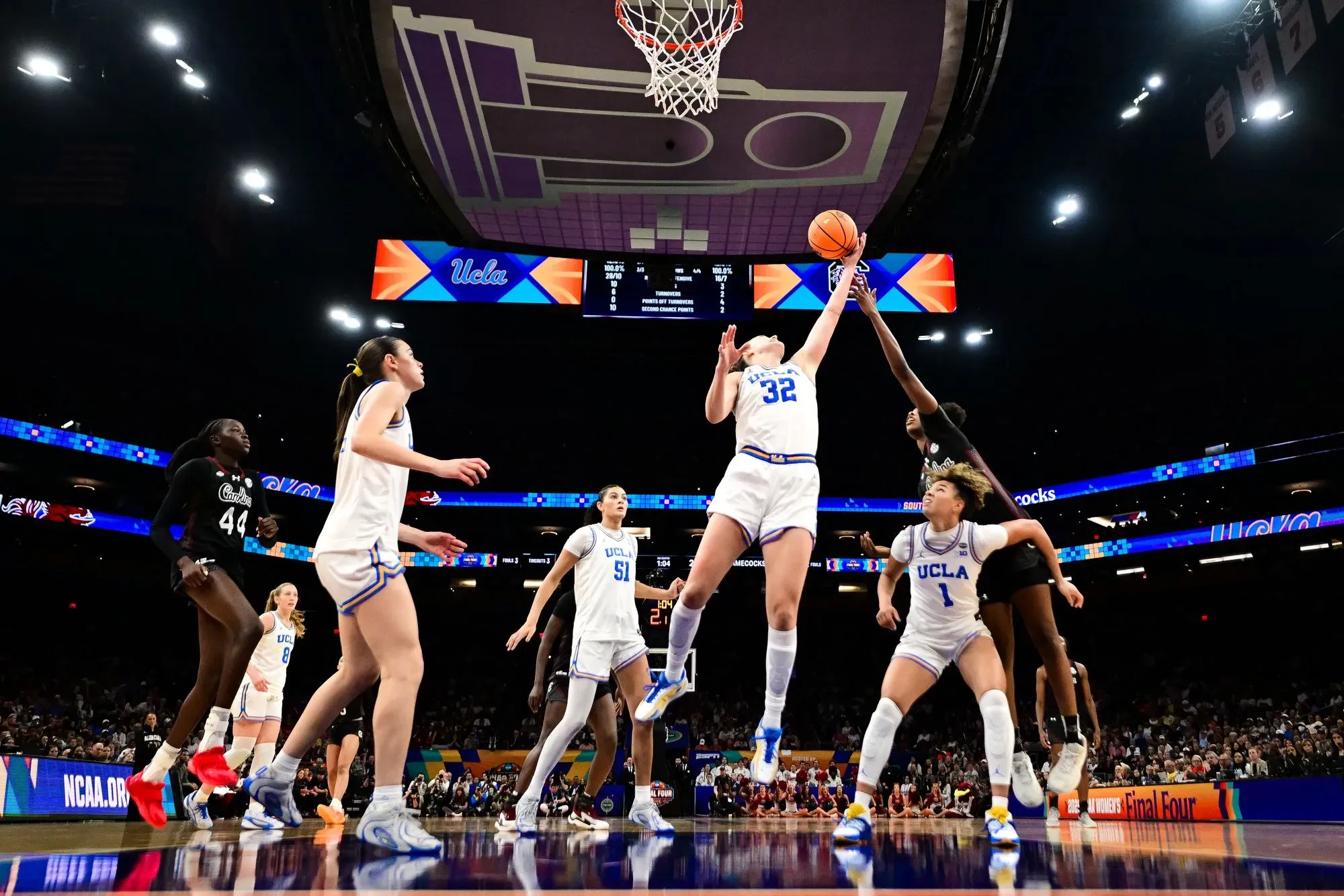 لاعبة كرة سلة من جامعة كاليفورنيا في لوس أنجلوس تسجل نقطة خلال مباراة البطولة الوطنية ضد كارولينا الجنوبية، وسط أجواء حماسية.