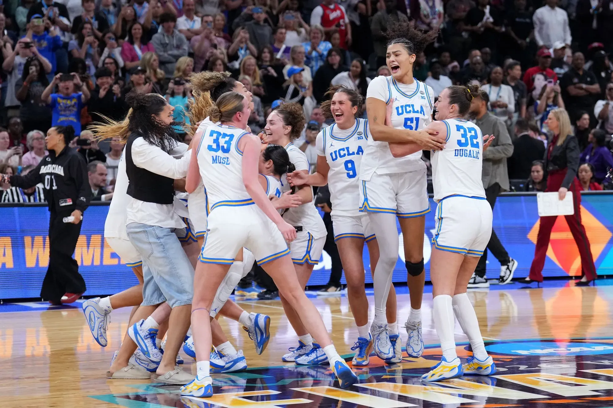 فريق جامعة كاليفورنيا في لوس أنجلوس يحتفل بفوزهم التاريخي بلقب البطولة الوطنية للسيدات، مع تعبيرات الفرح والنجاح.