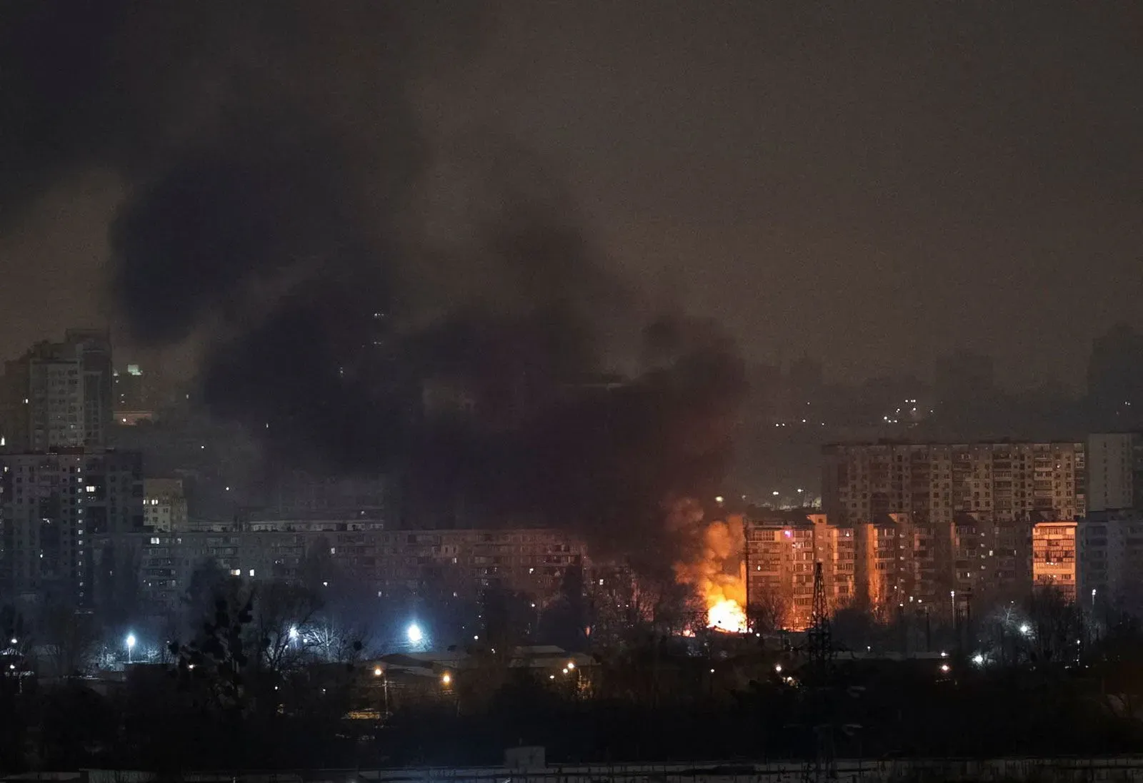 دخان كثيف يتصاعد من مباني في كييف بعد هجمات جوية روسية، مع اشتعال النيران في أحد المواقع، مما يعكس الأضرار الناتجة عن الغارات.