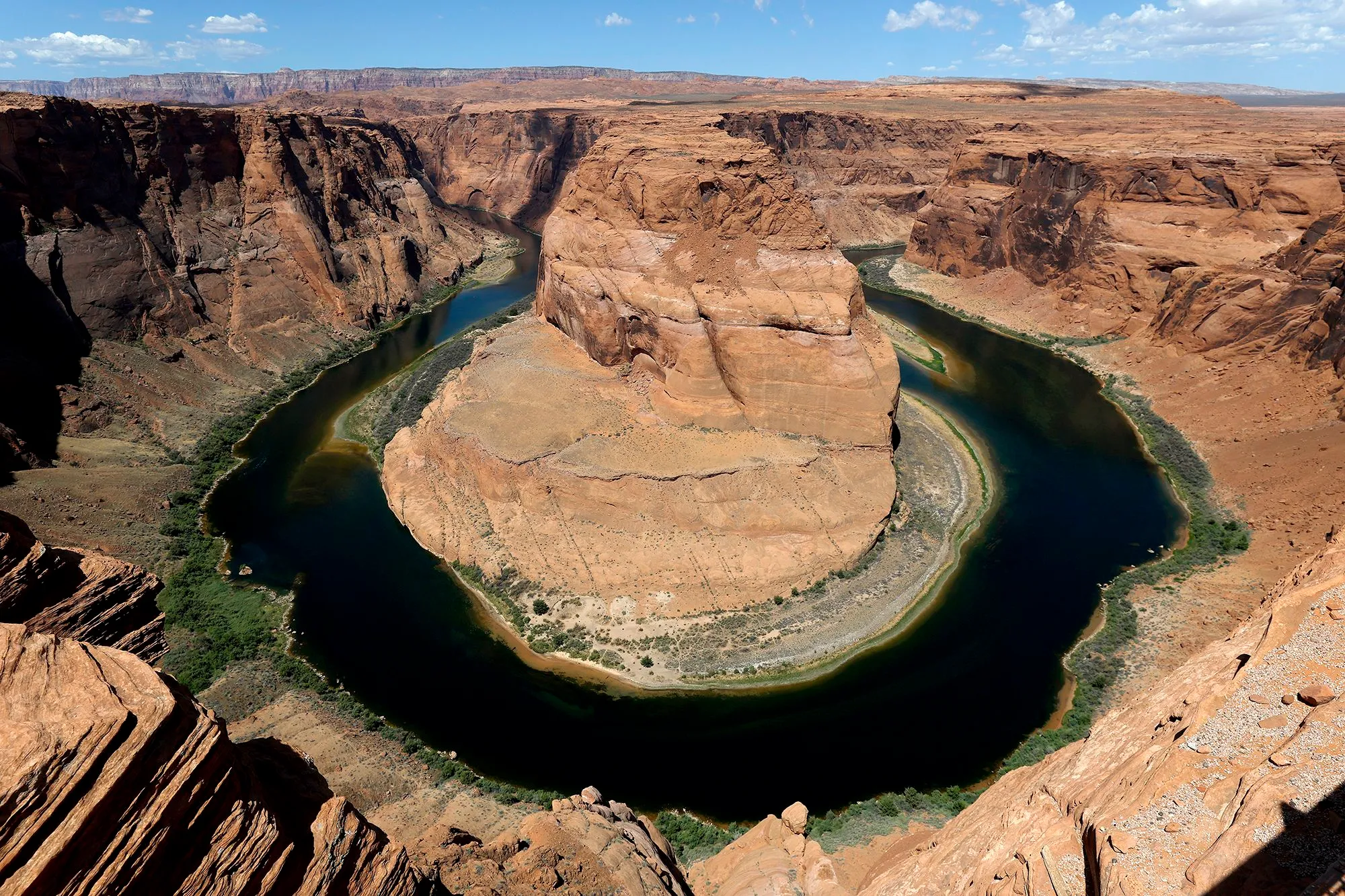 منظر جوي لنهر Colorado وهو يلتف حول تكوين صخري في منطقة Glen Canyon، يعكس أهمية النهر كمصدر مياه حيوي في غرب الولايات المتحدة وسط أزمة جفاف مستمرة.