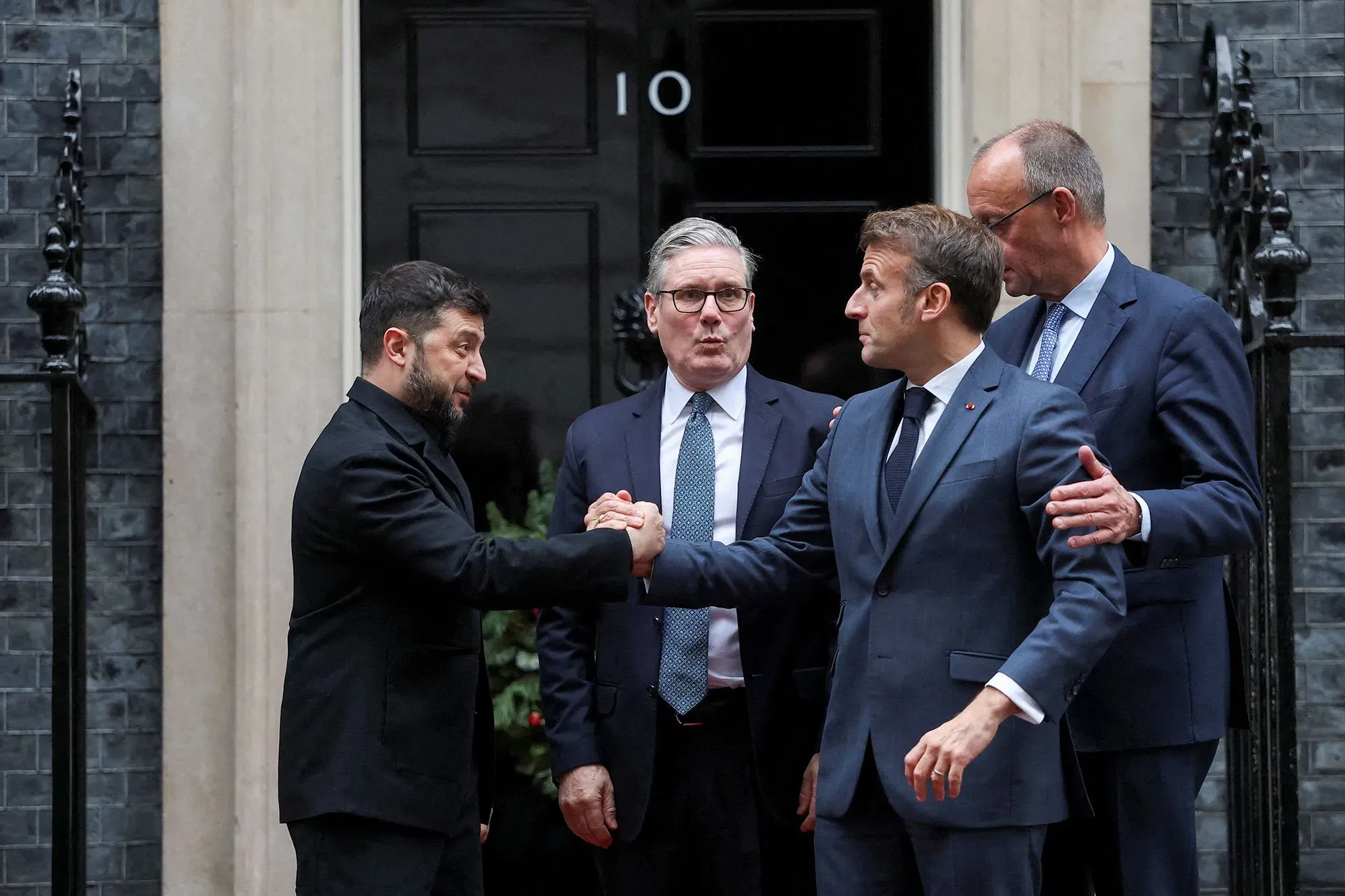 اجتماع قادة دوليين، بينهم زيلينسكي وماكرون، يتبادلون التحيات أمام مبنى رسمي، في سياق مناقشات حول خطة السلام لأوكرانيا.