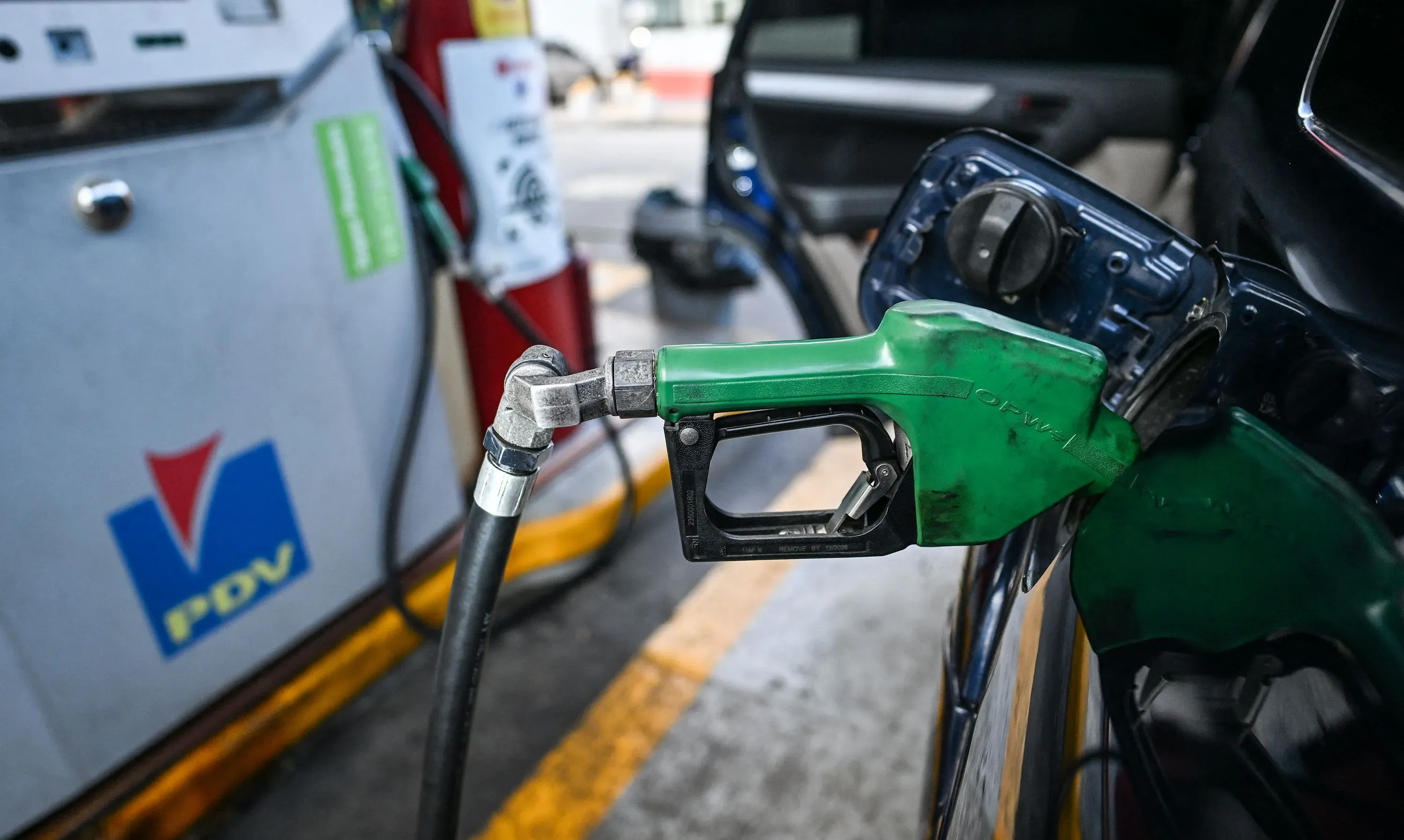 مضخة وقود خضراء في محطة، تُظهر ارتفاع الأسعار وتأثير التضخم على الحياة اليومية في فنزويلا، حيث يواجه المواطنون تحديات اقتصادية.