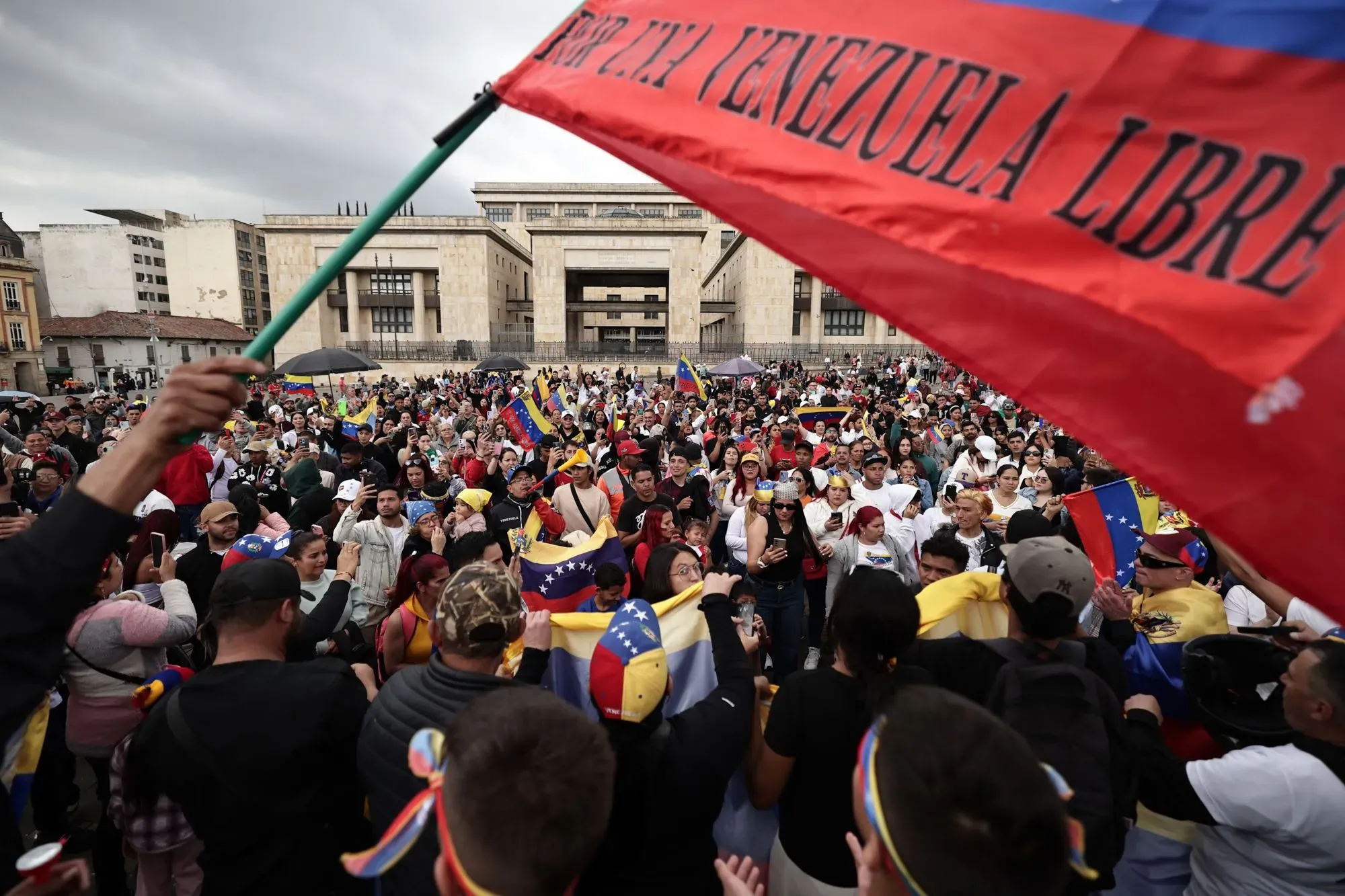 تجمع حشود من الفنزويليين في ساحة عامة، يحملون الأعلام ويعبرون عن دعمهم للحرية، في سياق الأزمة السياسية والاجتماعية في فنزويلا.