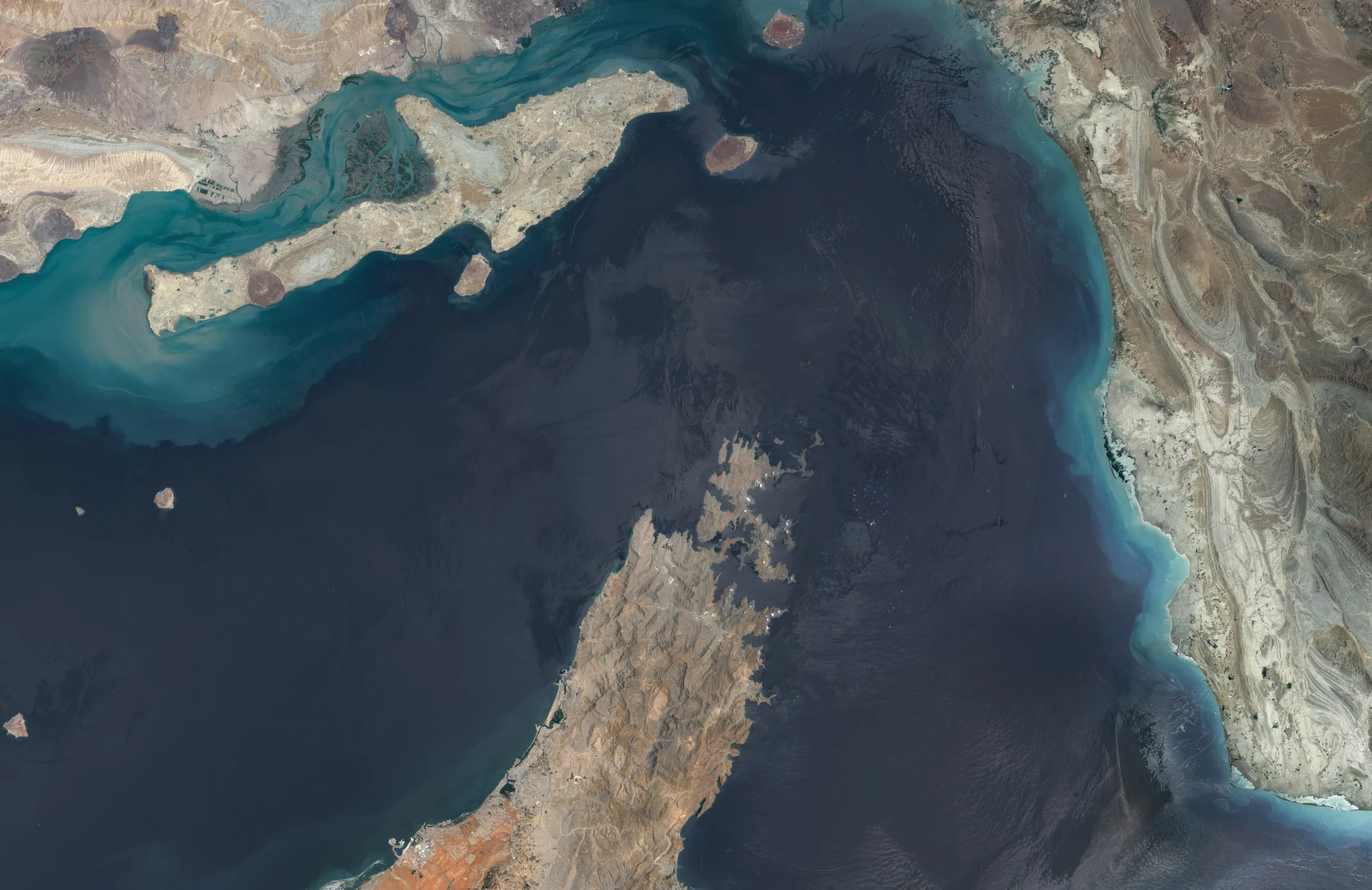 صورة فضائية لمضيق هرمز تظهر الممر المائي الحيوي بين إيران وسلطنة عمان، مع التركيز على أهمية المضيق في تدفق النفط العالمي.