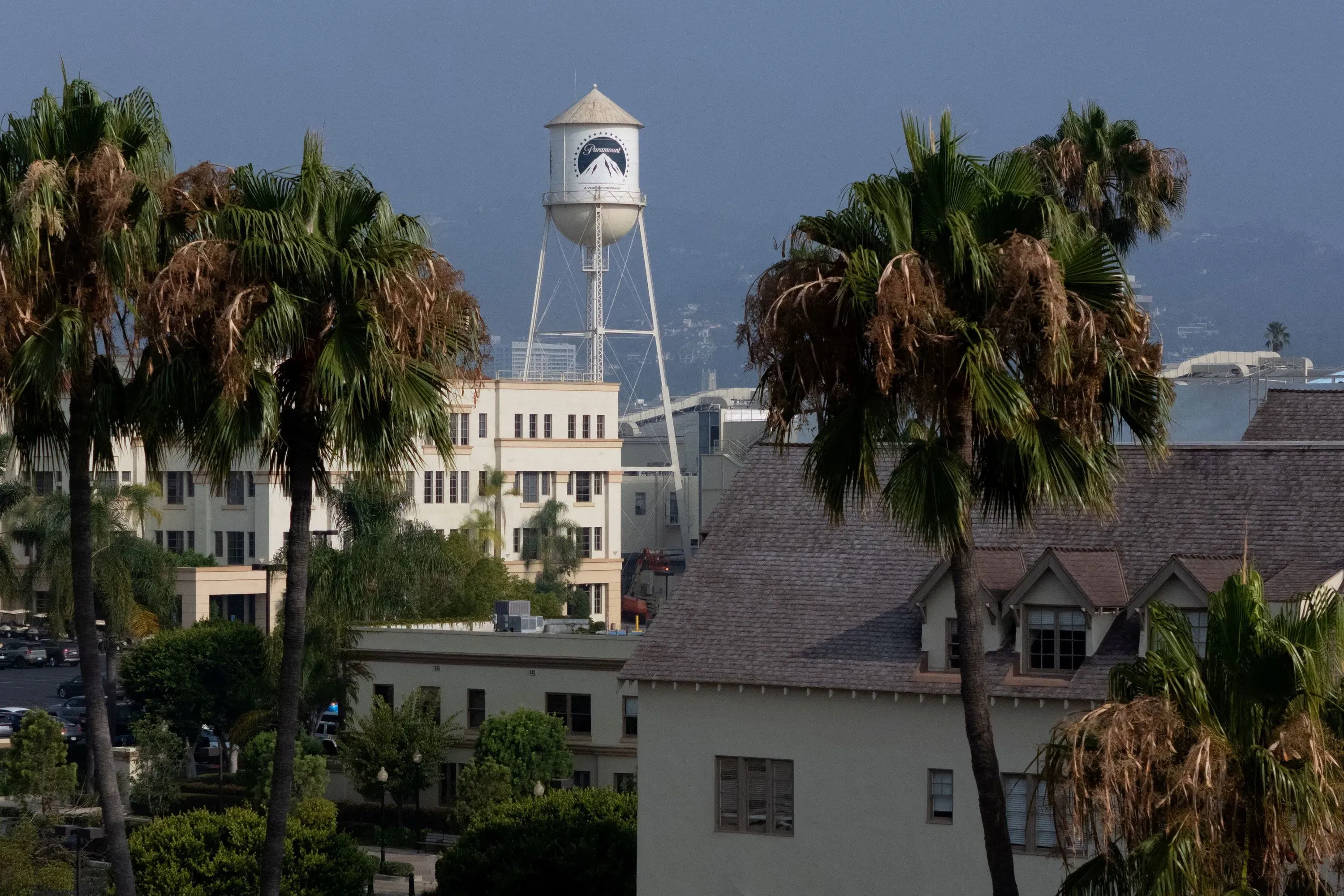صورة تظهر مبنى شركة باراماونت مع خزان مياه مميز في الخلفية، محاط بأشجار النخيل، تعكس أجواء هوليوود.