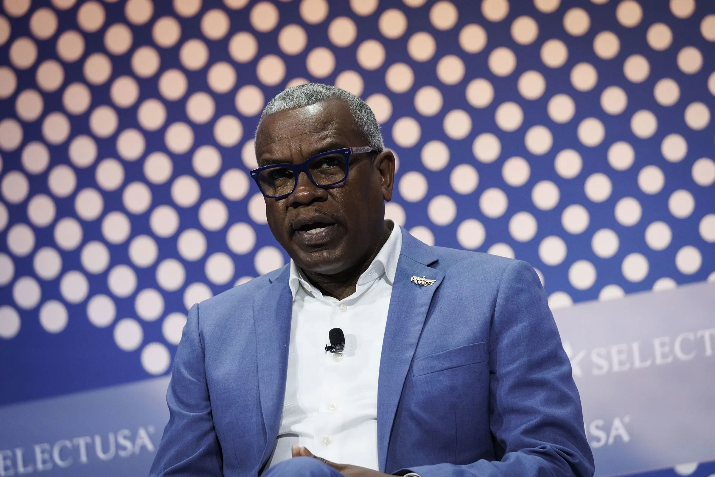 ألبرت بريان جونيور، حاكم جزر فيرجن الأمريكية، يتحدث خلال حدث عام، مع خلفية مزخرفة، في سياق قضايا تتعلق بجيفري إبشتاين.