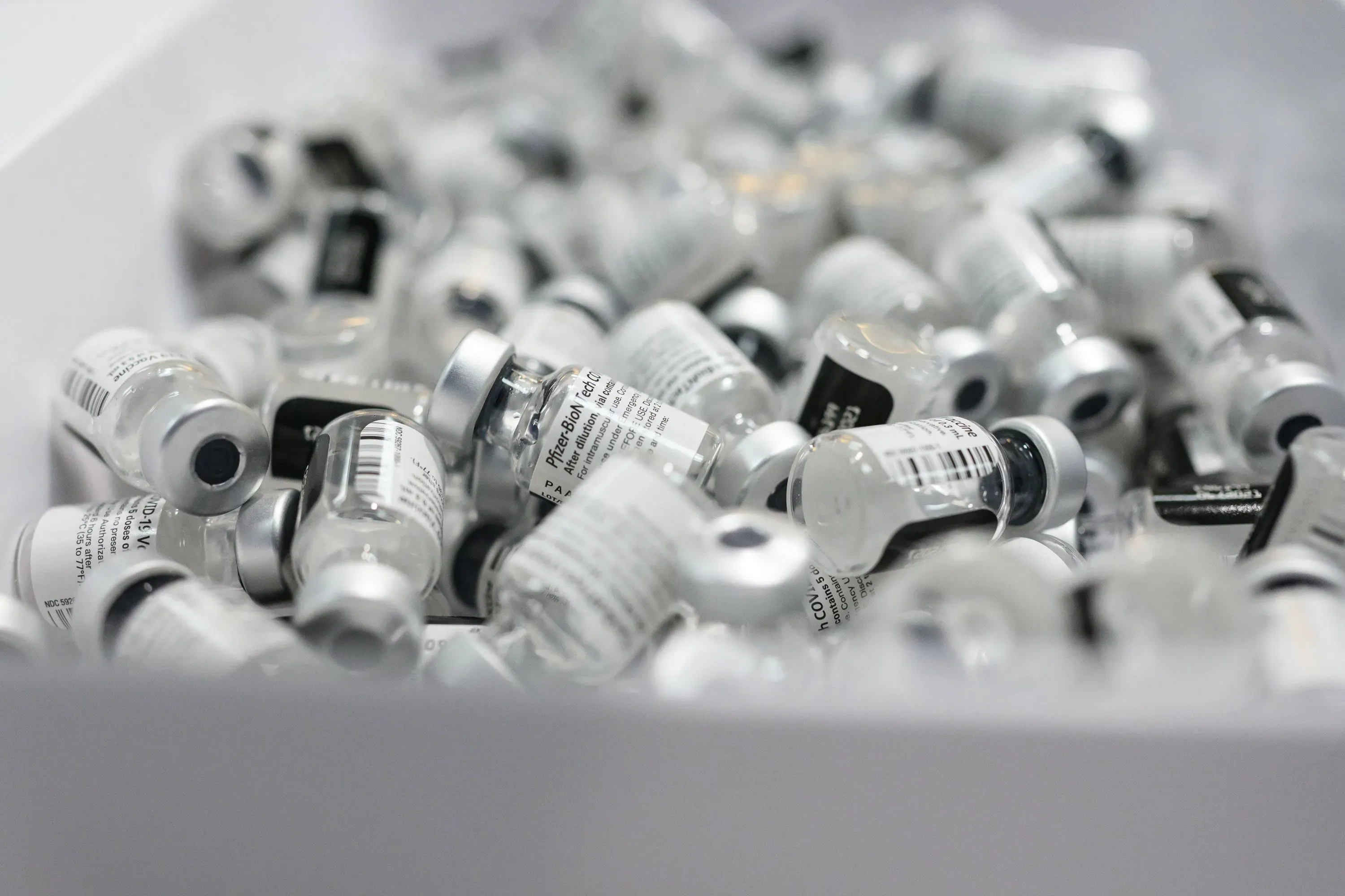 زجاجات لقاحات مكدسة في صندوق، تعكس جهود ولاية فرجينيا الغربية في تحقيق معدلات تطعيم عالية لحماية الأطفال من الأمراض.