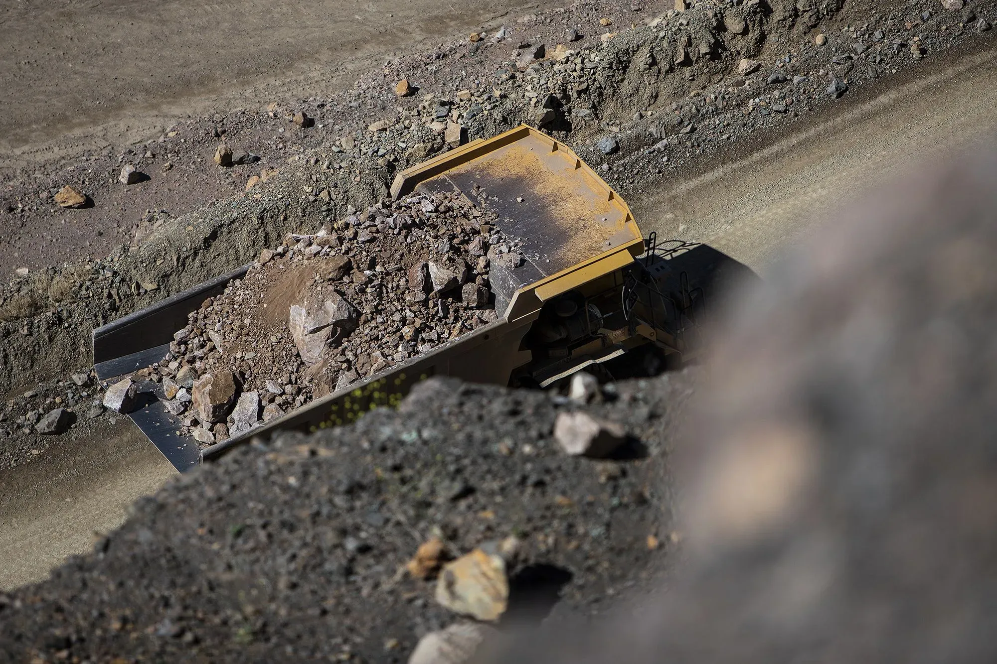 شاحنة نقل كبيرة محملة بالصخور والمعادن في موقع تعدين، تعكس أهمية المعادن الأرضية النادرة في الحرب التجارية بين الولايات المتحدة والصين.