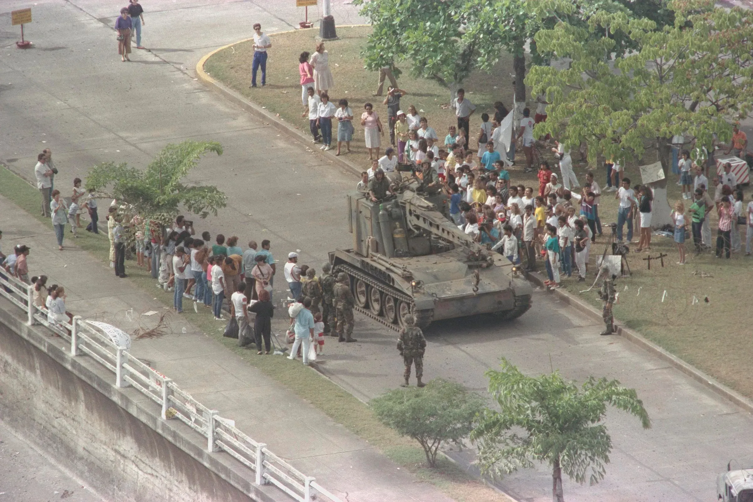 مجموعة من الناس يتجمعون حول دبابة في باناما خلال فترة الاضطرابات العسكرية، مما يعكس التوترات السياسية في ذلك الوقت.