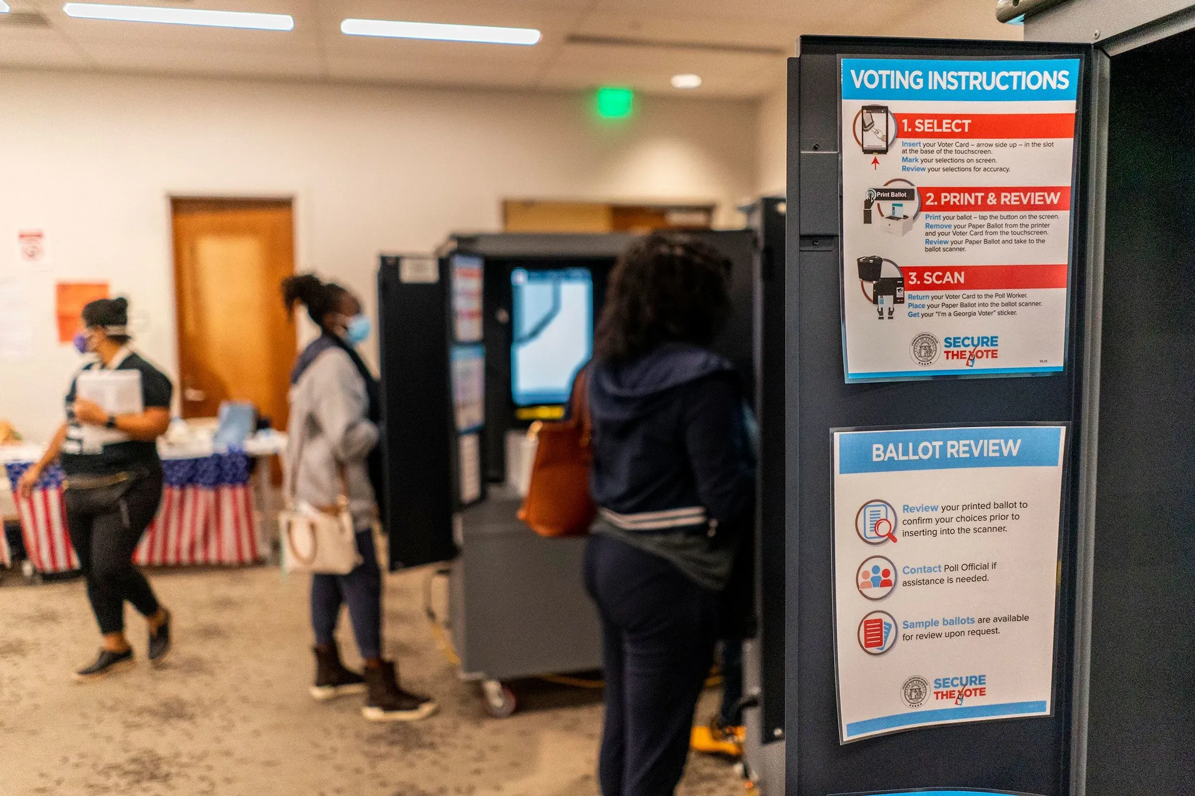 مركز اقتراع في جورجيا يظهر تعليمات التصويت، مع ناخبين يتفاعلون مع آلات الاقتراع، في سياق الجدل حول نزاهة الانتخابات.