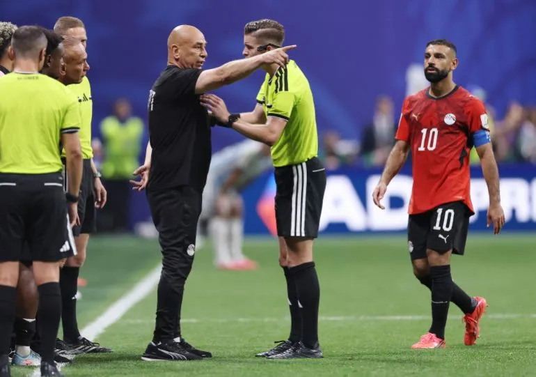المدرب حسام حسن يحتج على حكم المباراة خلال مواجهة مصر والأرجنتين في كأس العالم وسط توتر واحتجاجات على قرارات التحكيم.