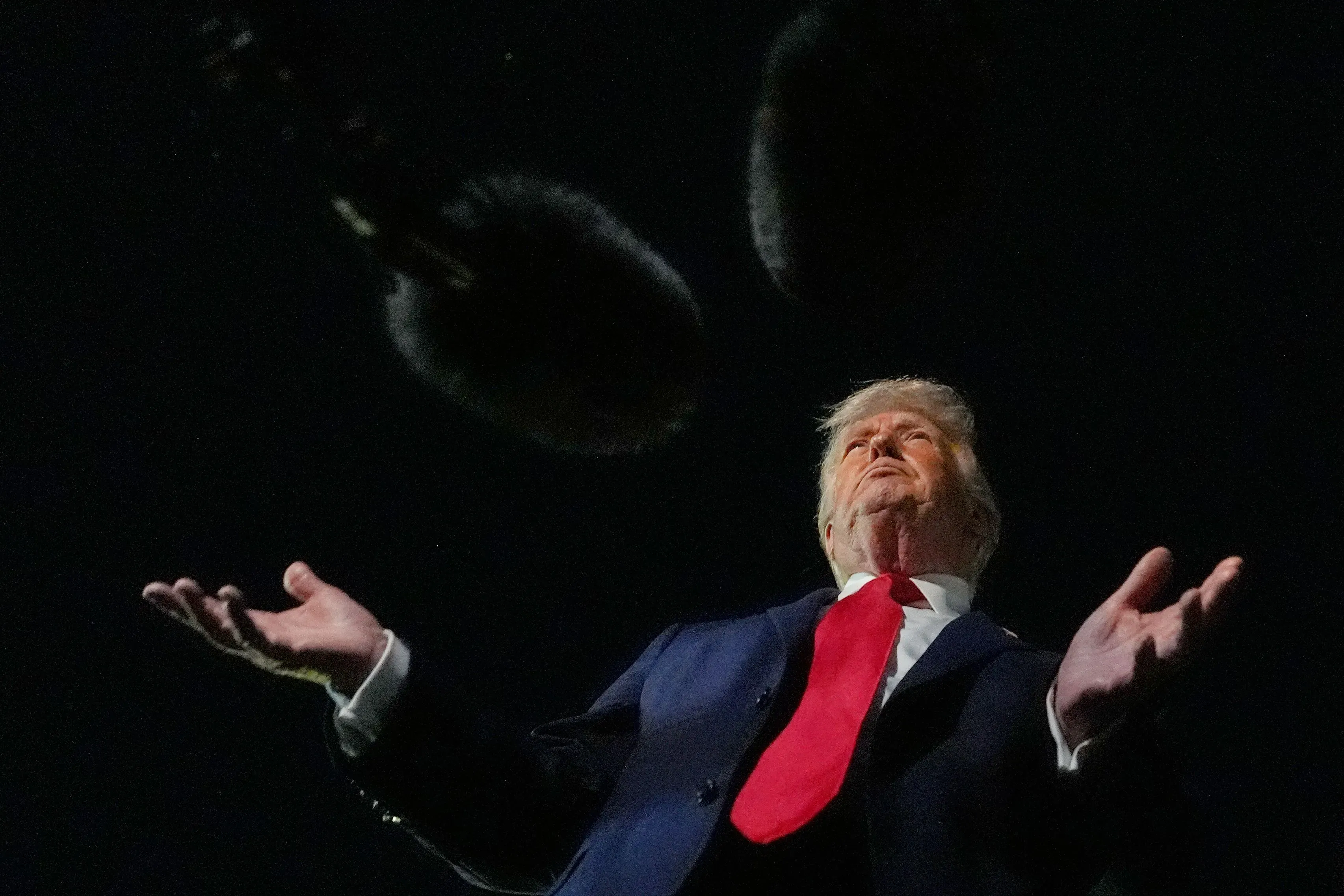 ترامب يتحدث أثناء حدث عام، مع مايكروفونات معلقة في الهواء، معبرًا عن آرائه حول الانتخابات ونزاهتها.