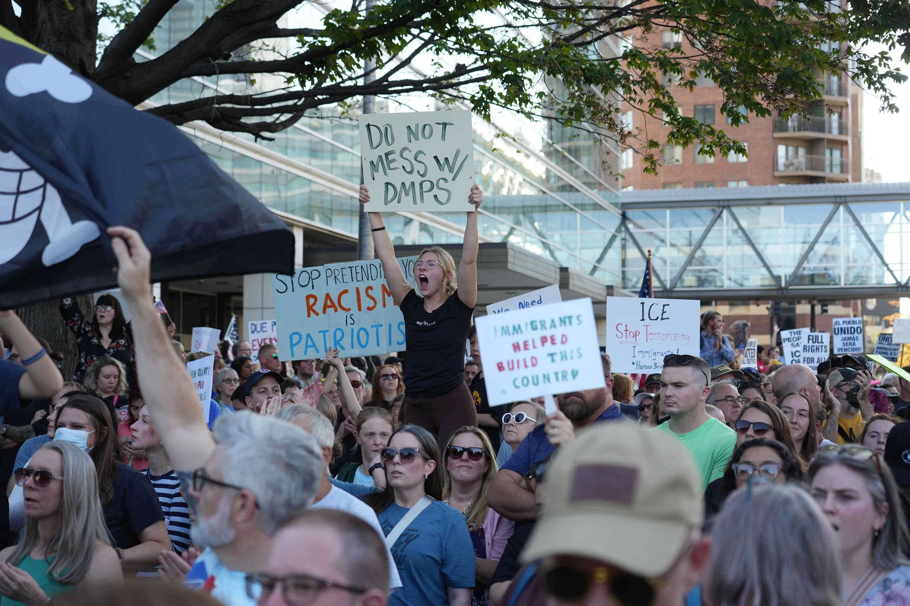 احتجاج حاشد في دي موين، حيث يحمل المتظاهرون لافتات تدعو إلى حقوق المهاجرين، مع وجود شعارات ضد التمييز والعنصرية.