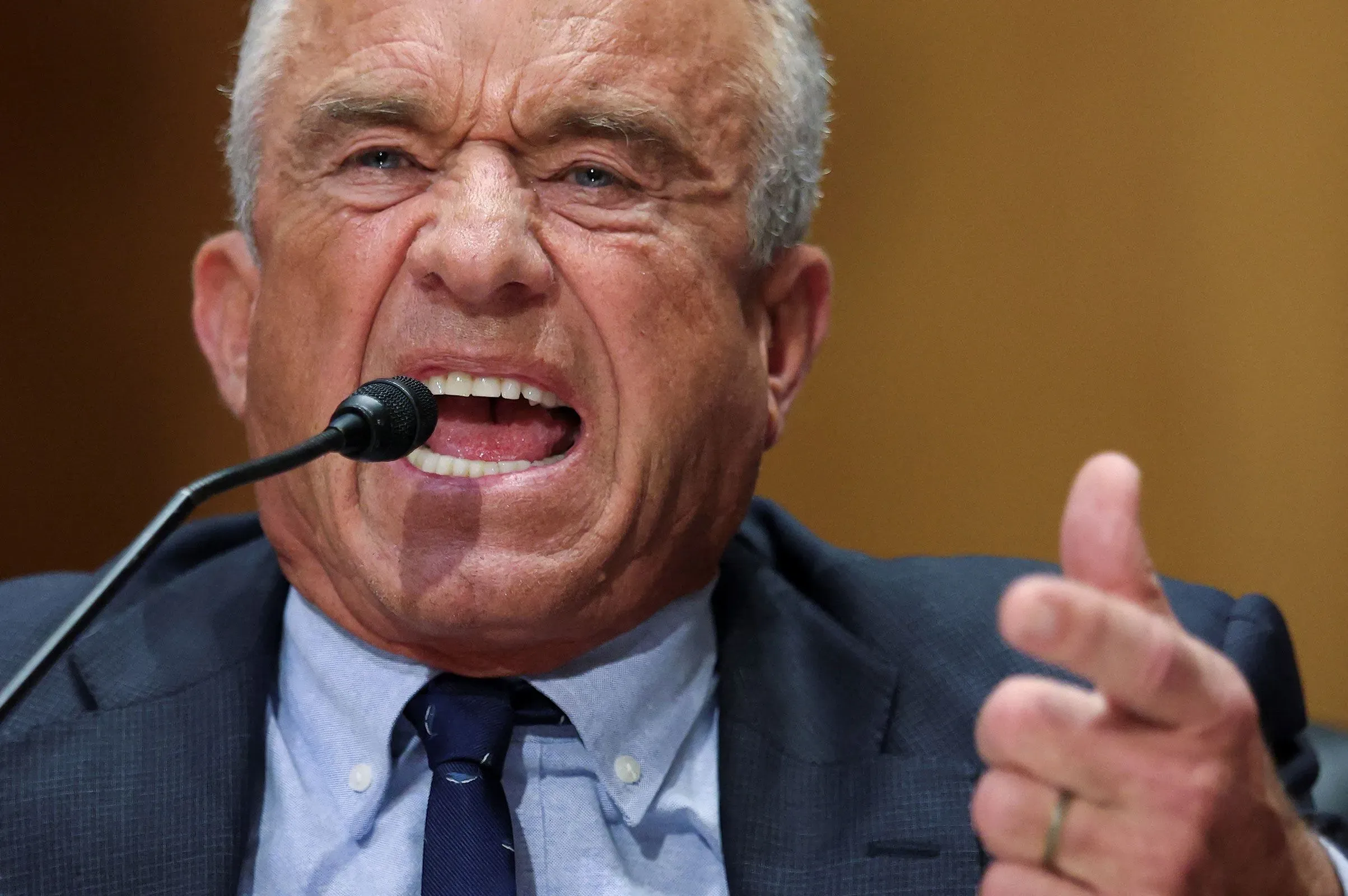 تعبير حماسي لروبرت ف. كينيدي جونيور أثناء حديثه في جلسة استماع، حيث يعبر عن آرائه حول قضايا الرعاية الصحية.