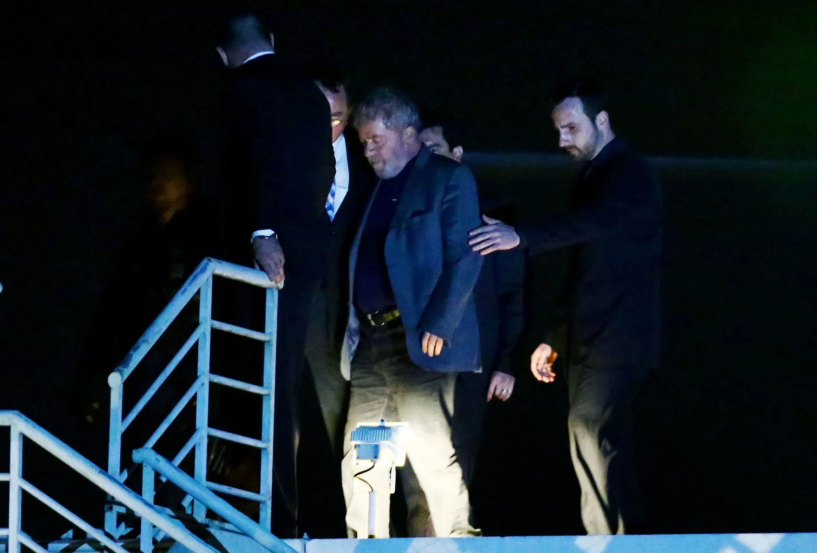 رئيس البرازيل السابق جايير بولسونارو يخرج من طائرة برفقة حراسه، بعد إدانته بالتآمر لإلغاء انتخابات 2022.