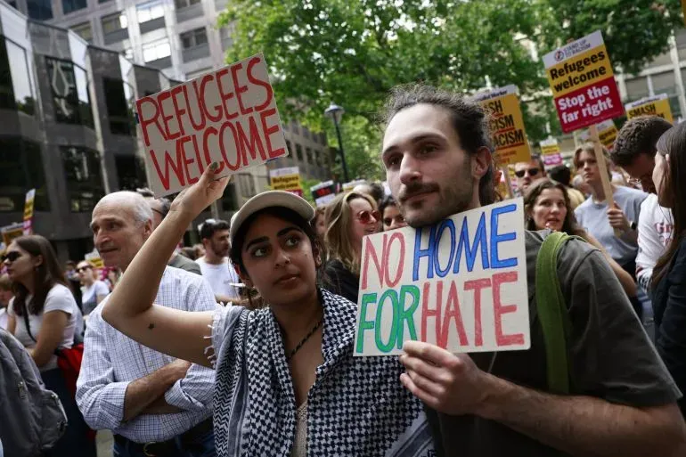 محتجون يحملون لافتات تدعو إلى استقبال اللاجئين ويعارضون الكراهية، في تظاهرة تعكس قضايا الهجرة في المملكة المتحدة.