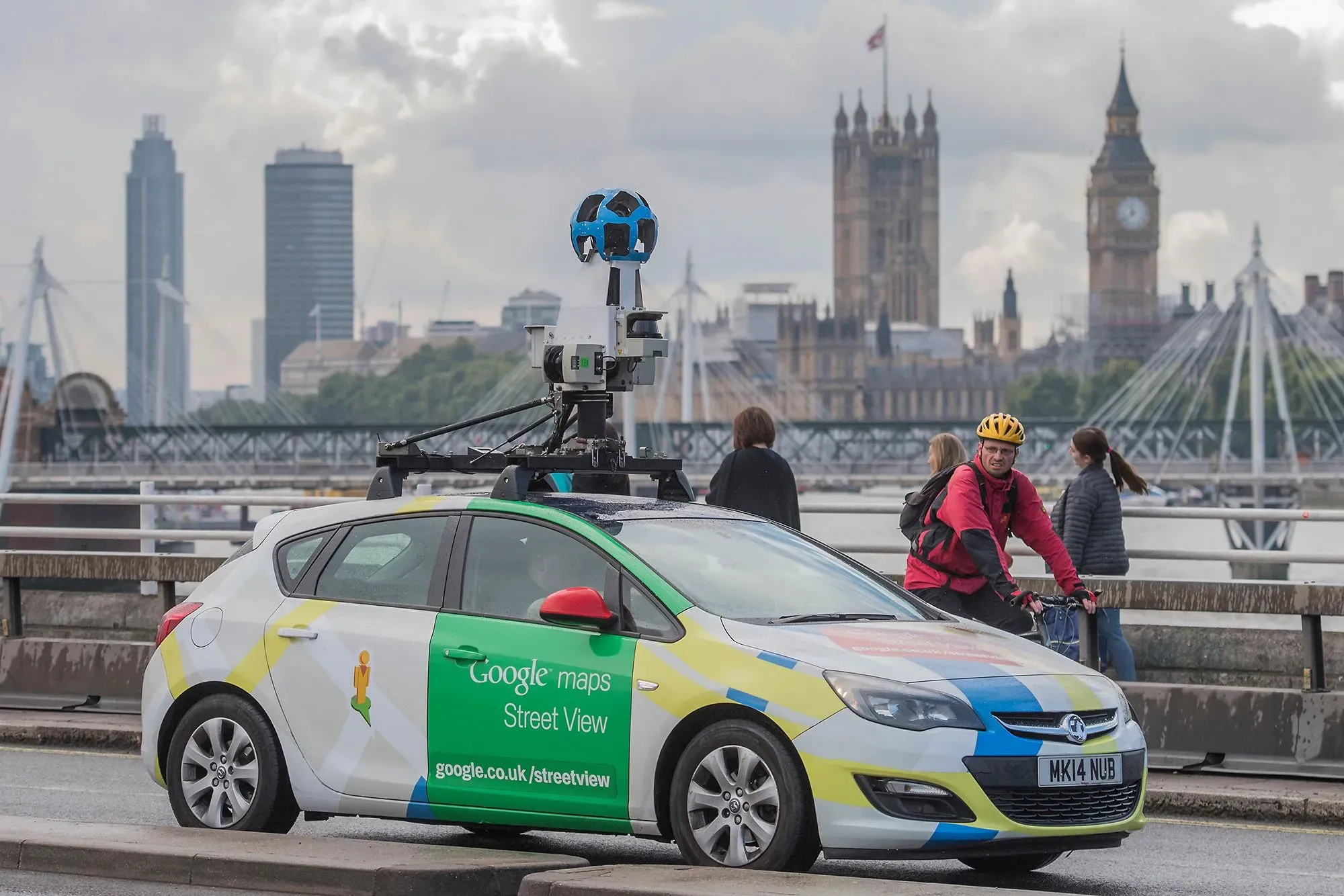 سيارة مزودة بكاميرات خرائط جوجل تسير على جسر في مدينة، مع معالم بارزة في الخلفية، تعكس تحديات التنقل في كوريا الجنوبية.