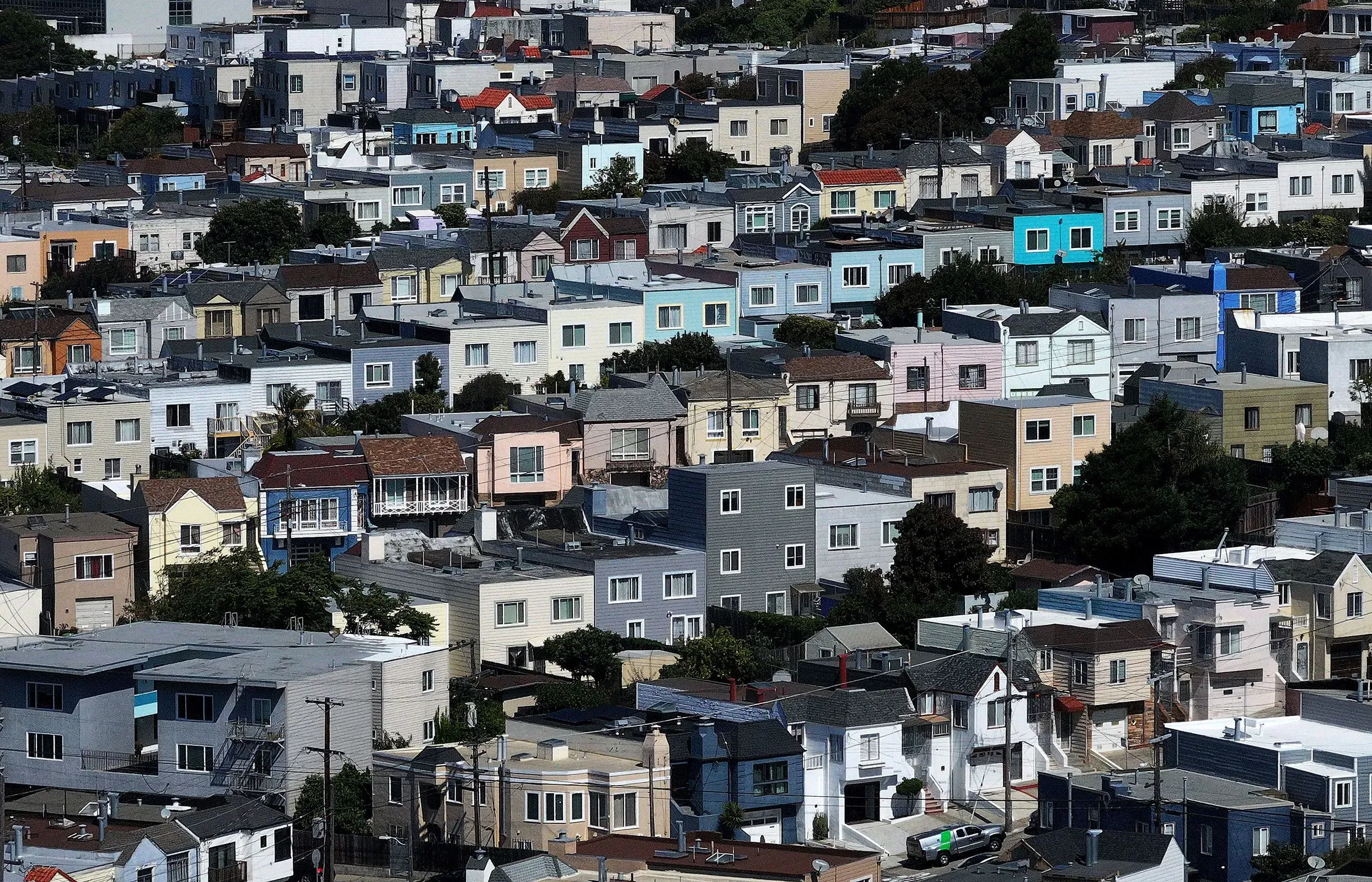 صورة تُظهر منظرًا جويًا لمجموعة من المنازل الملونة في حي سكني، تعكس التفاوت الاقتصادي في المجتمع الأمريكي.