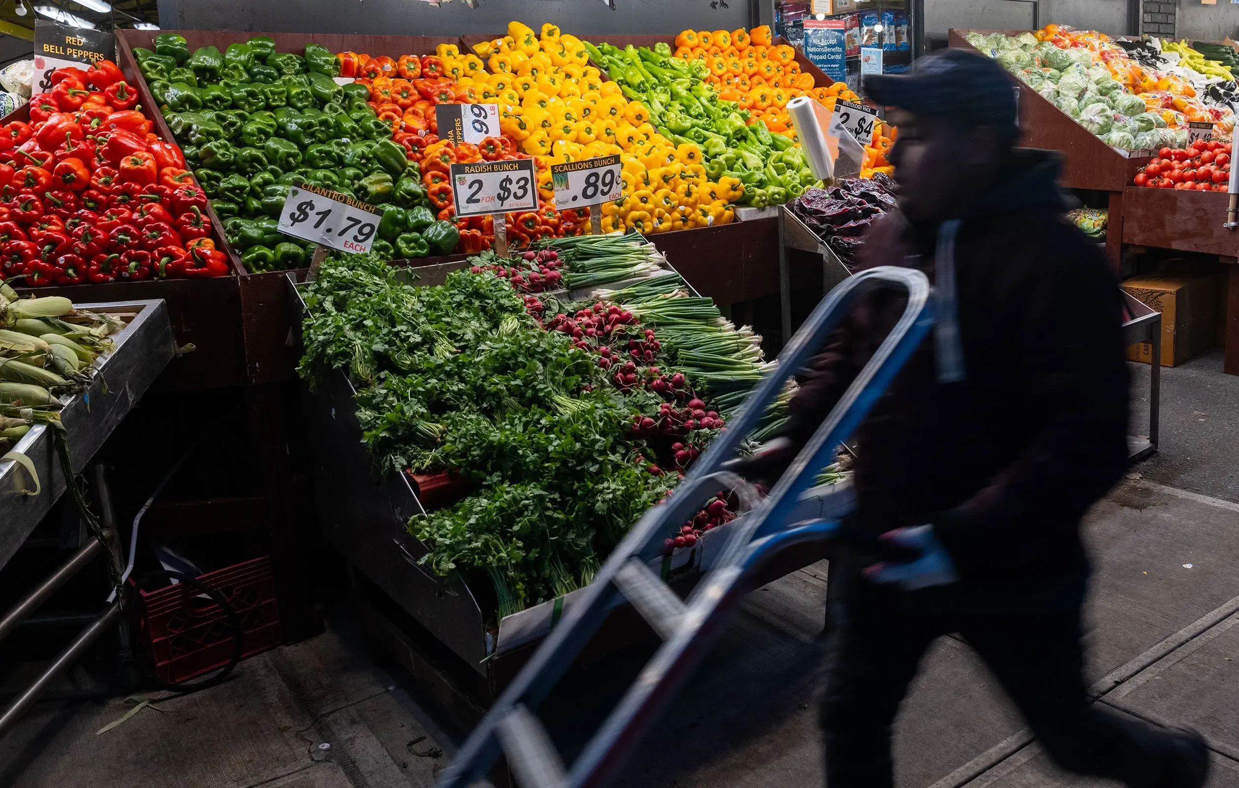 مشهد لسوق خضار مليء بالفلفل الأحمر والأخضر والبرتقالي، مع علامات أسعار توضح تكلفة المنتجات، يعكس التحديات الاقتصادية الحالية.