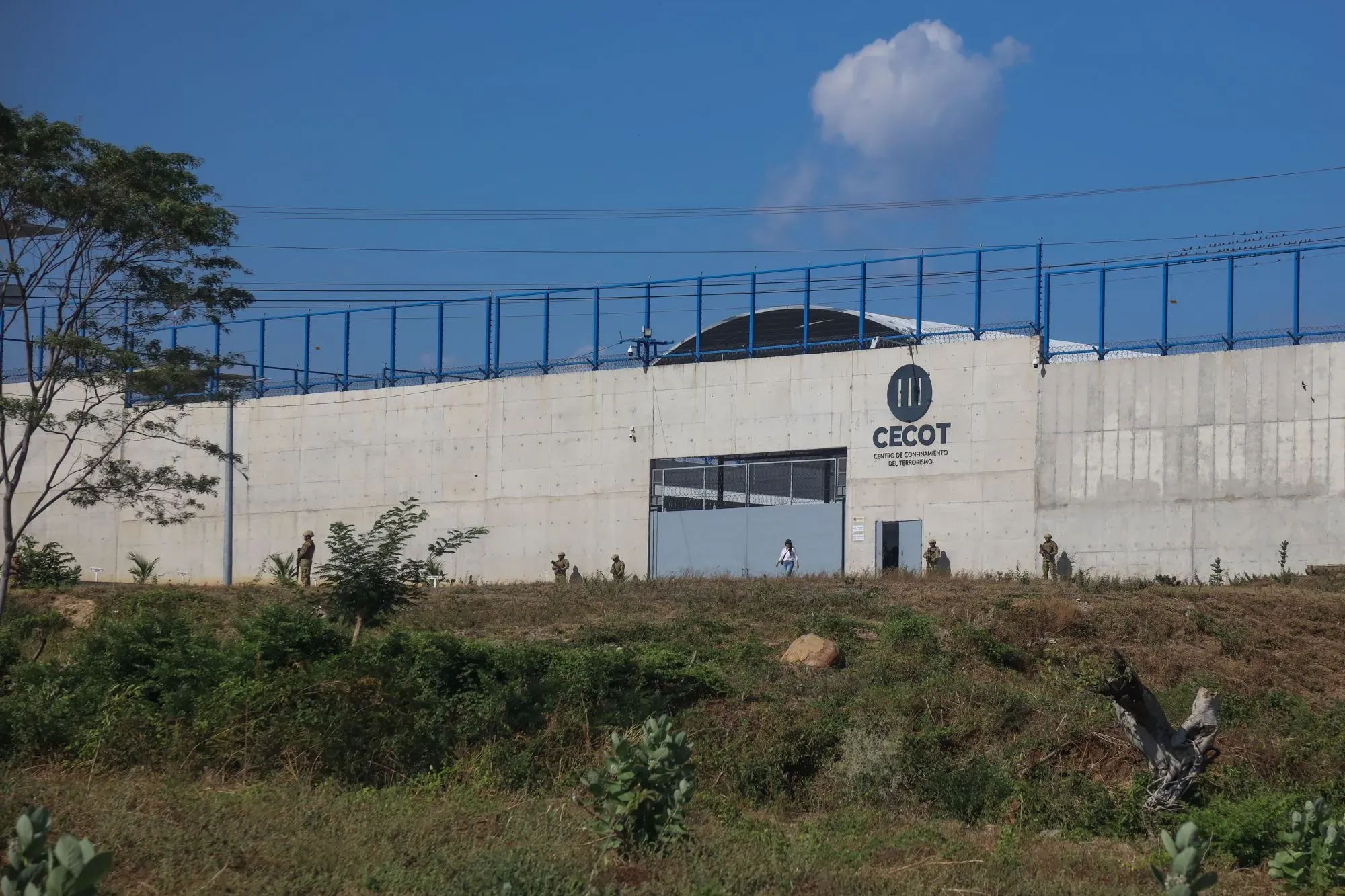 مبنى سجن CECOT في فنزويلا، يظهر حراس الأمن والبيئة المحيطة، يعكس التحديات التي تواجهها السجون في أمريكا اللاتينية.