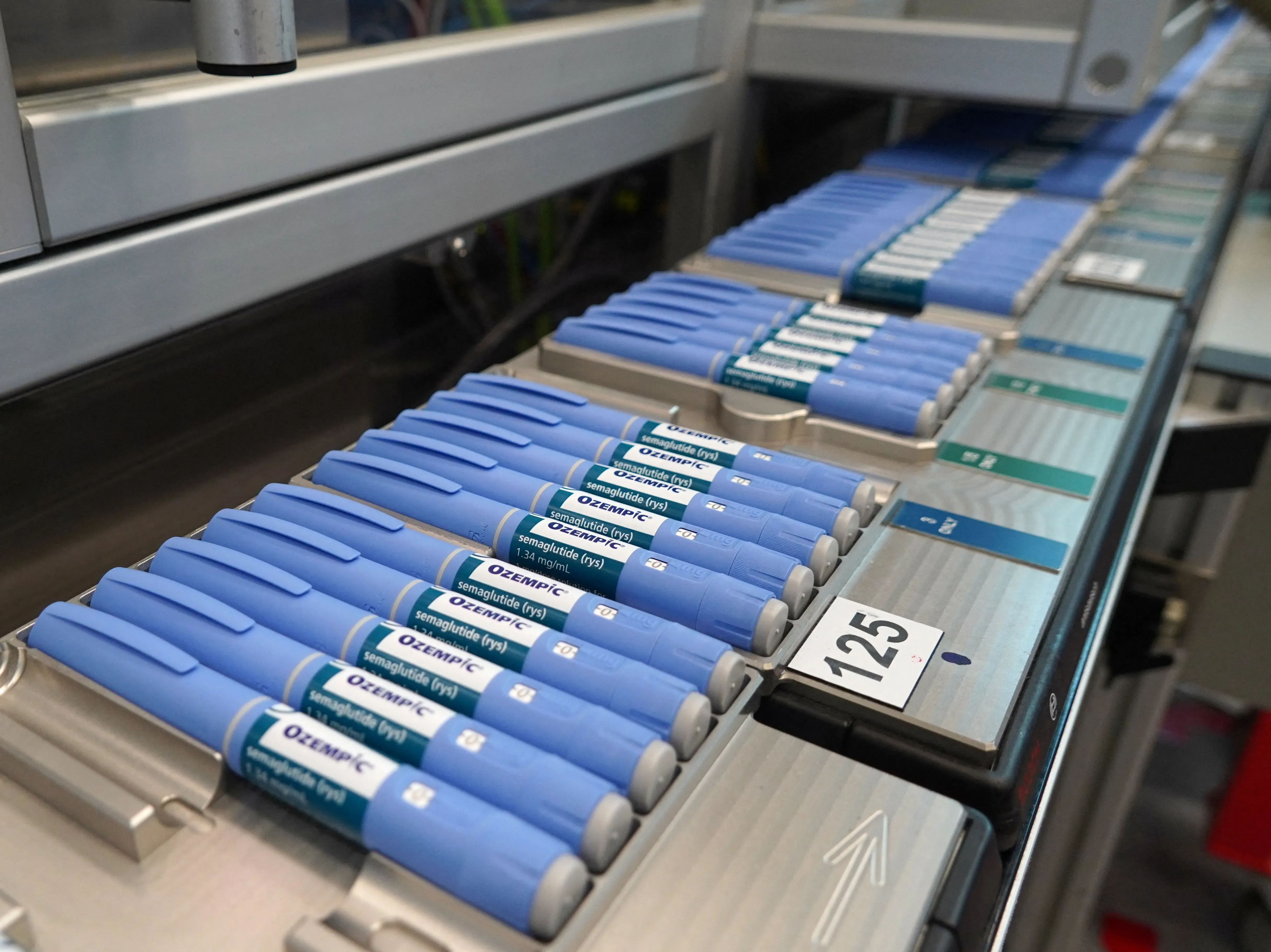 أقلام حقن أوزيمبك الزرقاء مرتبة في صفوف، تمثل جزءًا من النقاش حول فقدان الوزن واضطرابات الأكل في الثقافة المعاصرة.