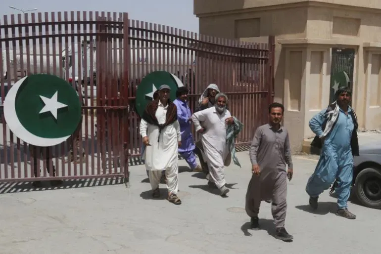 مجموعة من الرجال يخرجون من بوابة تحمل شعار باكستان، في سياق مناقشات حول طرق بديلة لنقل البضائع إلى إيران.