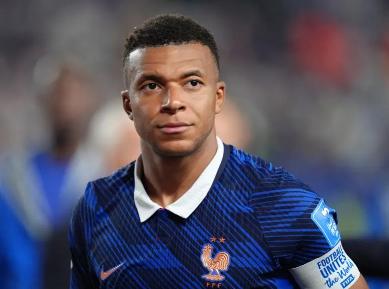 صورة لكليان مبابي، نجم منتخب فرنسا، يرتدي قميص فريقه الأزرق مع شعار الاتحاد الفرنسي، ويظهر تعبيره الجاد قبل مباراة كأس العالم 2026.