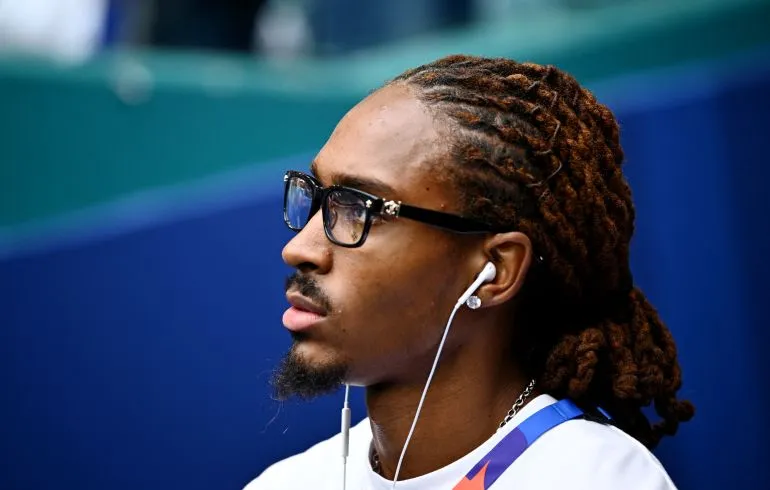 اللاعب دجد سبينس يرتدي نظارات وسماعات أذن، يعكس تركيزه قبل مباراة إنجلترا في كأس العالم، رمز للإلهام والتمثيل الإسلامي في كرة القدم الإنجليزية.