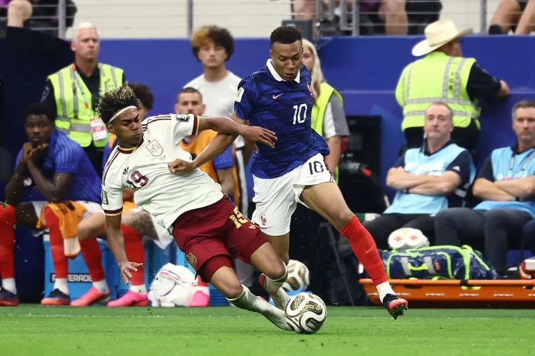 لاعب كرة القدم لامين يمال يرتدي زي إسبانيا يتنافس على الكرة مع لاعب فرنسي في مباراة نصف نهائي كأس العالم 2026.