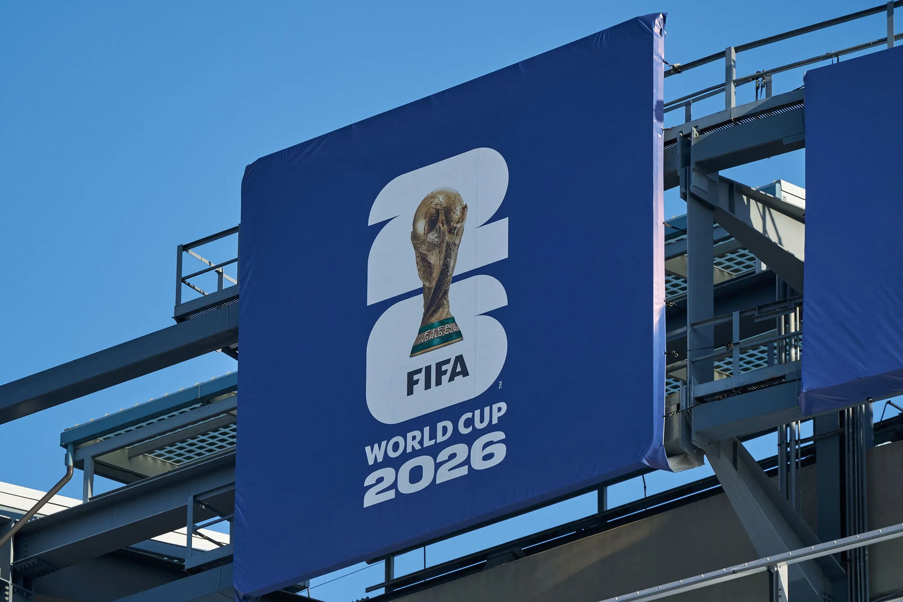 لافتة كبيرة تحمل شعار كأس العالم 2026، تظهر كأس البطولة مع تفاصيل FIFA، معلقة في ملعب MetLife Stadium.