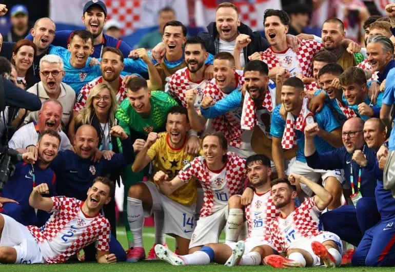 فريق كرواتيا يحتفل بعد الفوز في مباراة كأس العالم، مع ظهور اللاعبين والمدرب في أجواء من الفرح والانتصار.