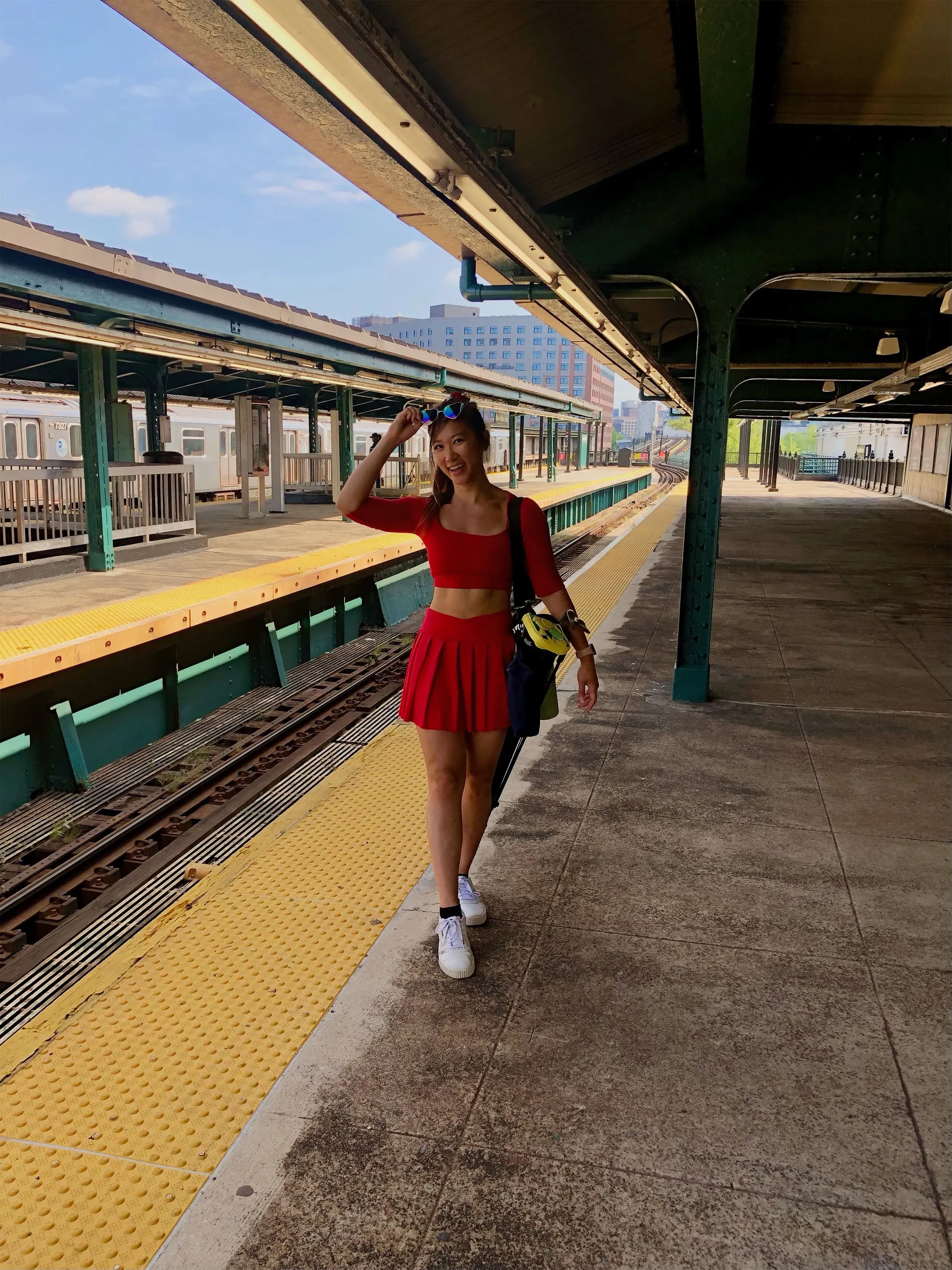 امرأة ترتدي ملابس رياضية حمراء وتبتسم بينما تسير على رصيف محطة قطار، تعكس روح المبادرة "الإغلاق العظيم" لتحقيق الأهداف الشخصية.