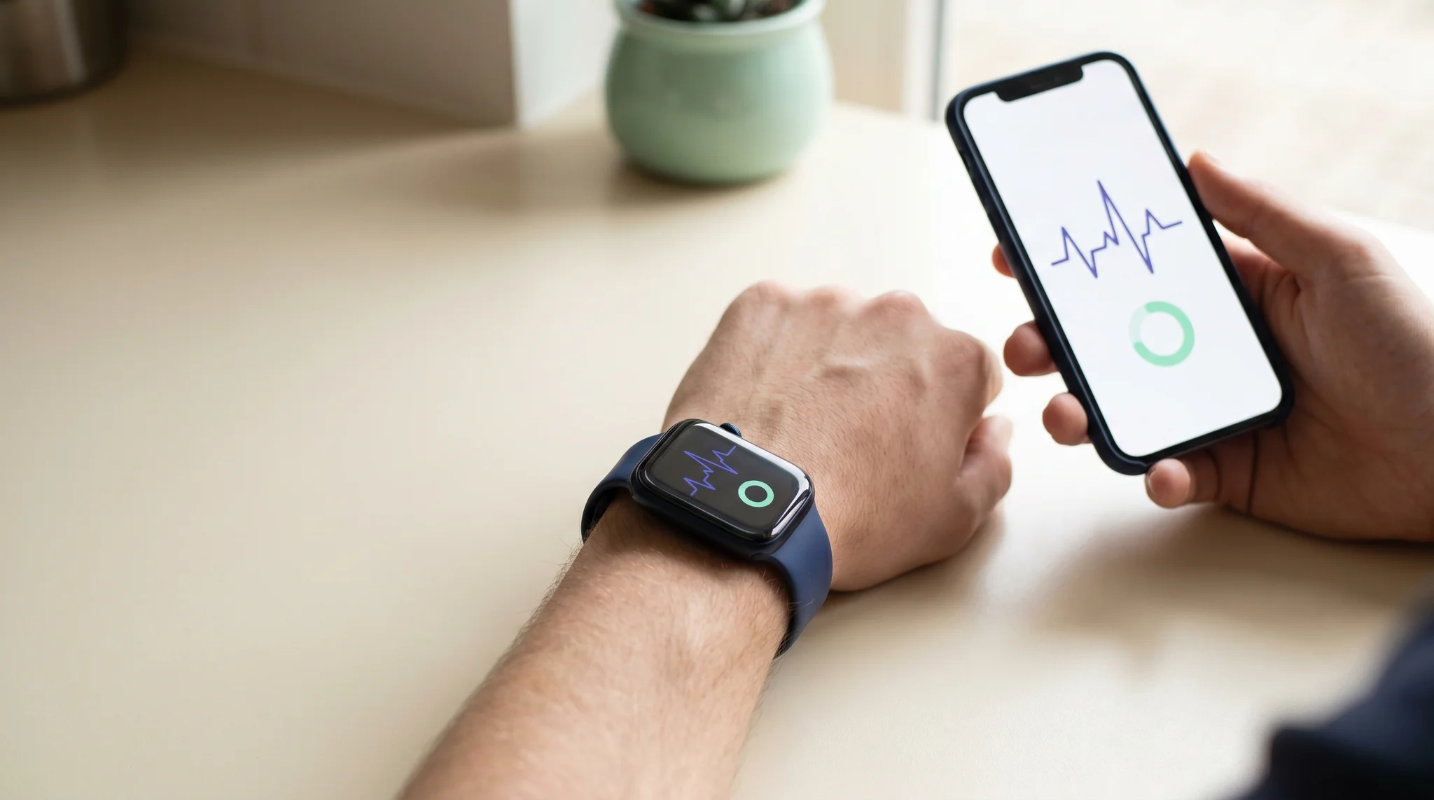 Close-up of a wrist and smartwatch with a phone app showing heart-rate data in a modern setting