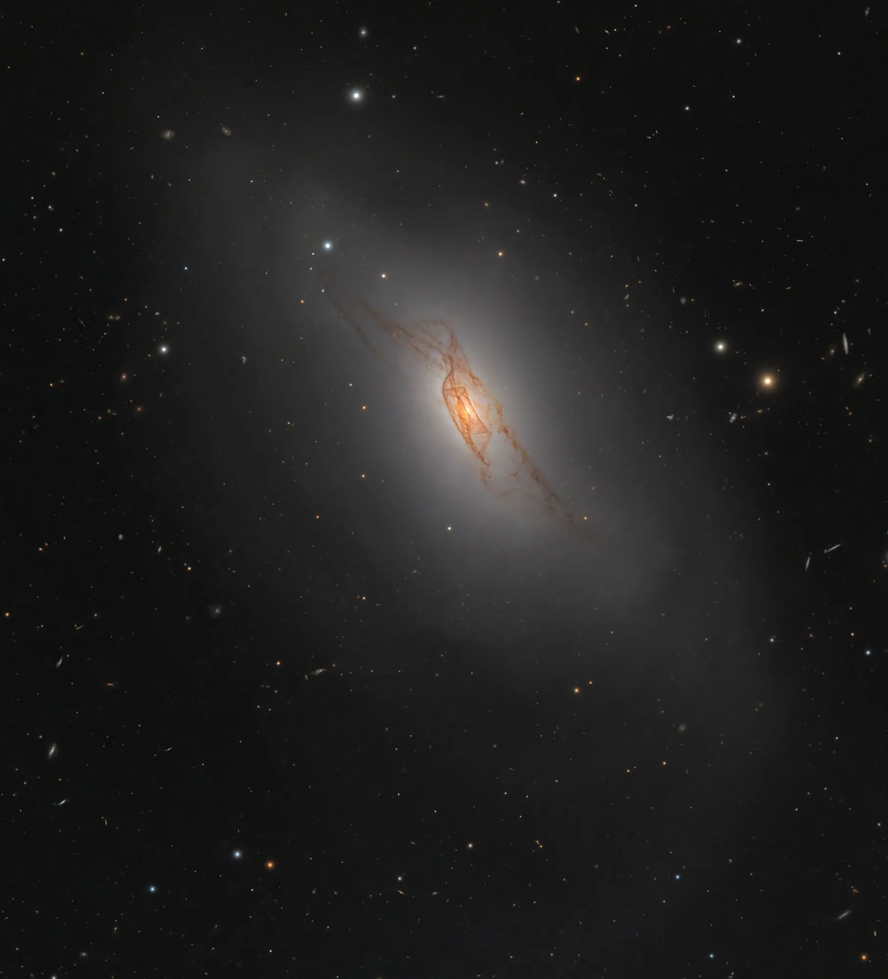 مجرة NGC 4371 في كوكبة العذراء تظهر تفاصيل الغبار الكوني وسط نجوم الخلفية في صورة فلكية عالية الدقة.