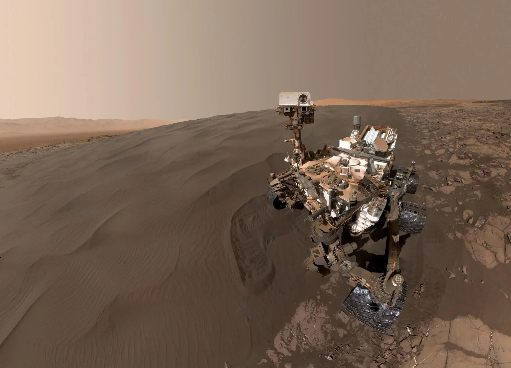 المركبة الجوّالة Curiosity على سطح المريخ بجانب كثيب رملي، مستمرة في استكشاف جبل شارب بعد أكثر من 14 عاماً من المهمة.