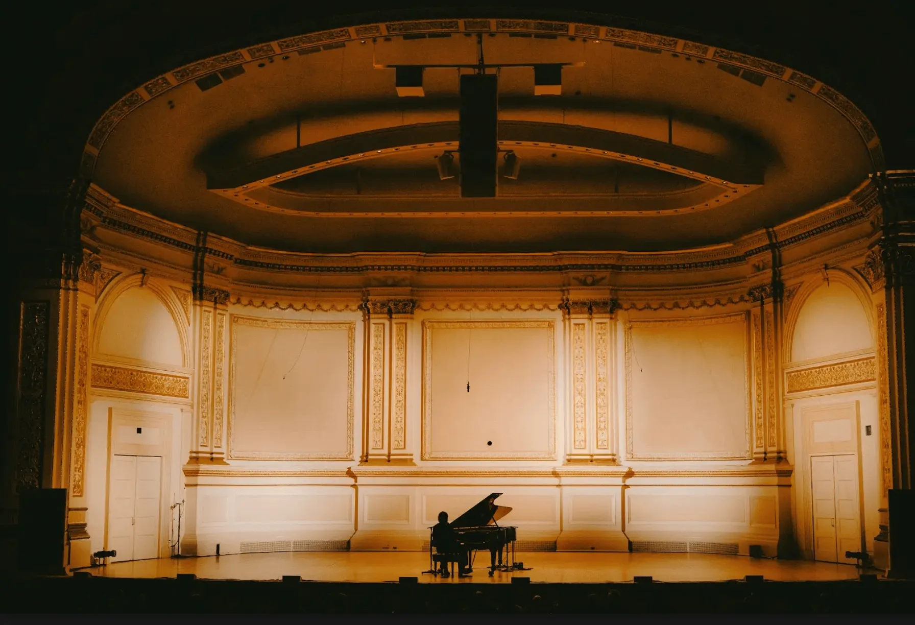 شاب يعزف على البيانو في قاعة كارنيغي الفارغة، مشهد من فيلم "Cameron Winter at Carnegie Hall" للمخرج Paul Thomas Anderson.