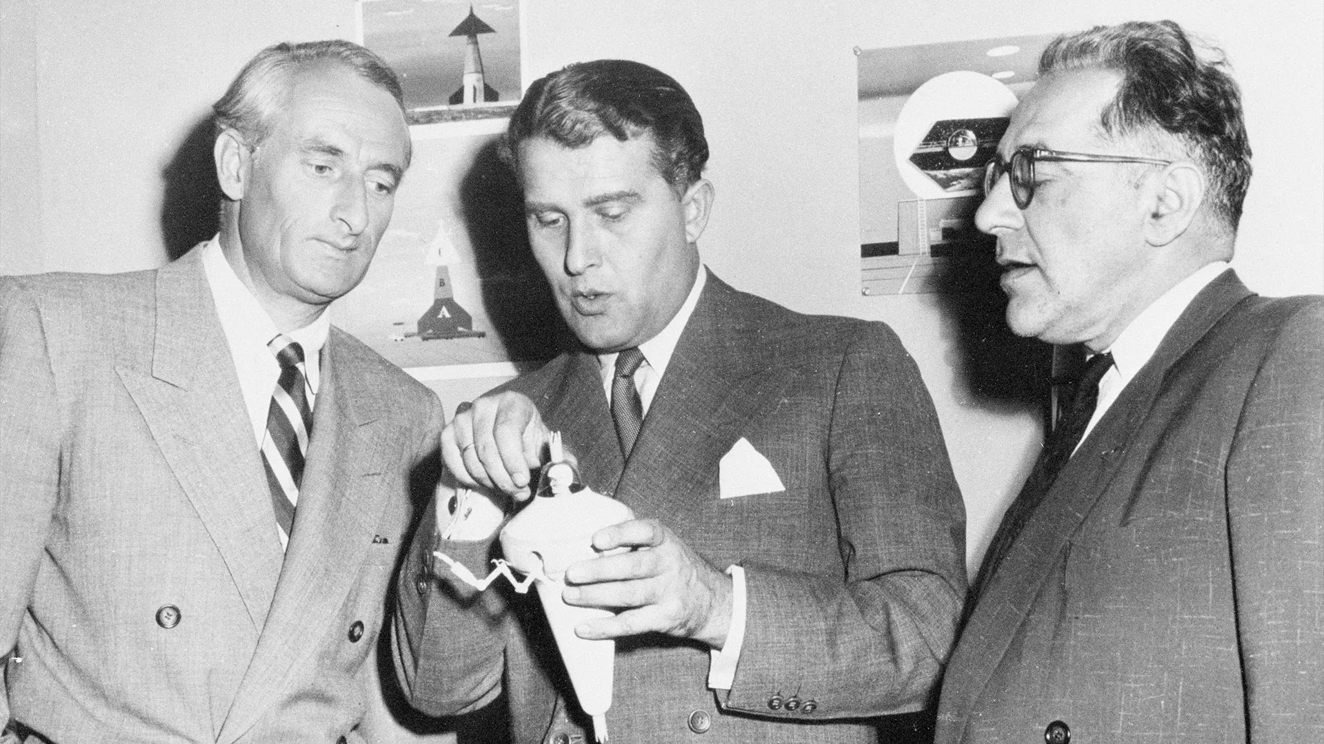 ثلاثة علماء فضاء بارزين يناقشون نموذج بذلة فضائية في عام 1964، ضمن تعاونهم مع ديزني لتقديم برامج تعليمية عن الفضاء.