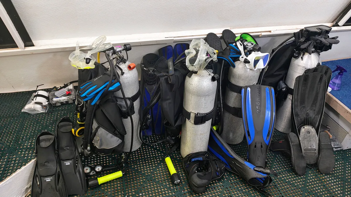 معدات غوص كاملة تشمل أسطوانات هواء، زعانف، وأقنعة مستخدمة في مهمة SEA STAR لمحاكاة بيئة الفضاء تحت الماء قبالة فلوريدا.