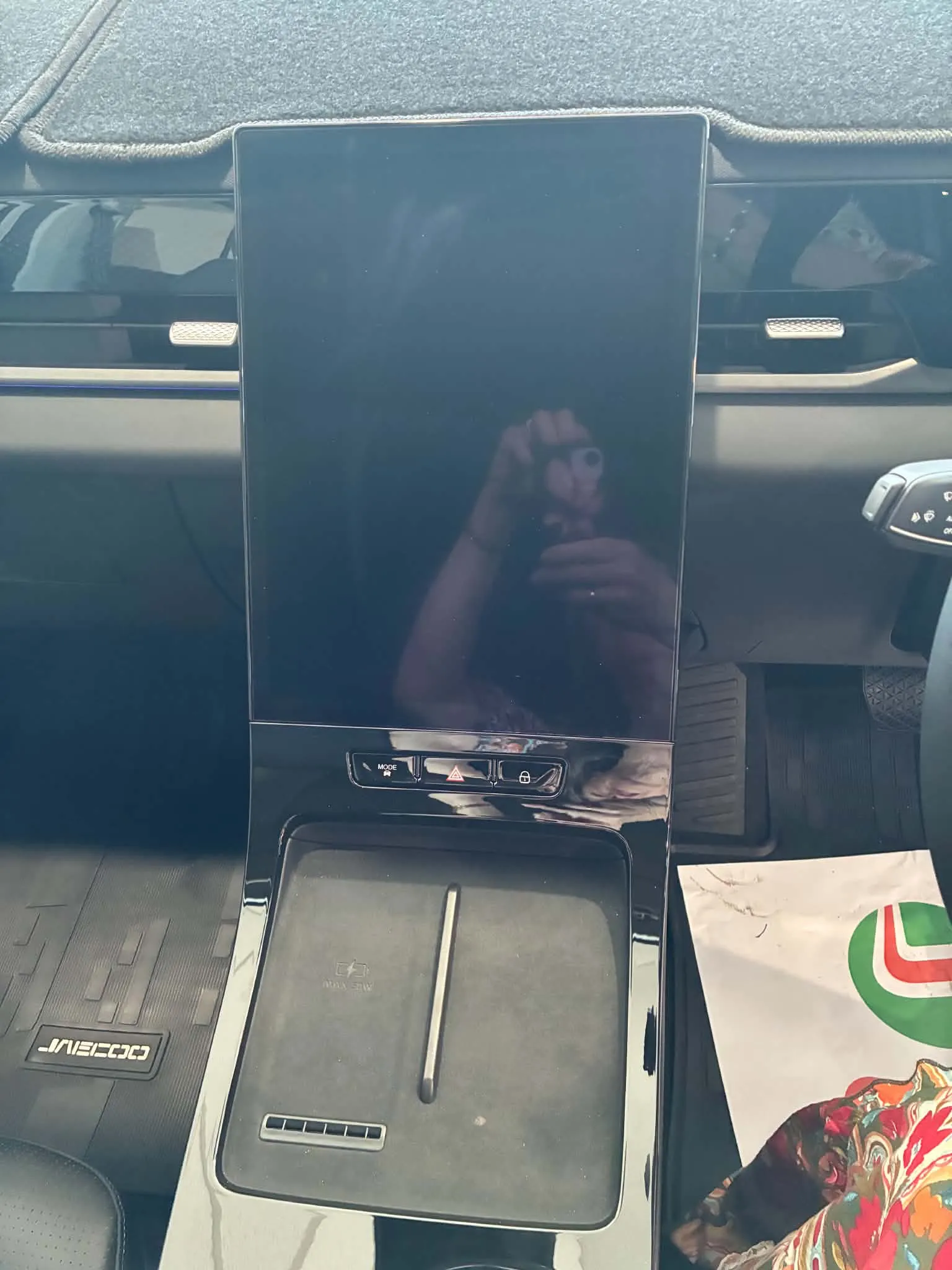 شاشة لمس كبيرة في لوحة تحكم سيارة كهربائية جايكو جيه5 مع مساحة شحن لاسلكي ومقابض تحكم أسفل الشاشة.