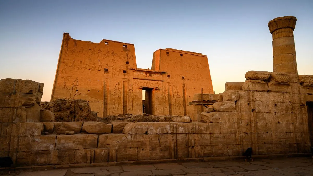 معبد الأقصر الأثري في ضوء الغروب مع نقوش فرعونية على جدرانه وأعمدته الحجرية القديمة.