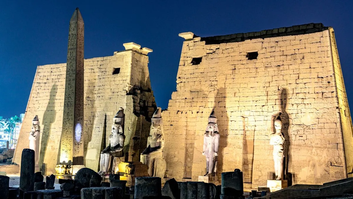 معبد الأقصر ليلاً مع إضاءة تبرز المسلة والنقوش الفرعونية، موقع تاريخي رئيسي في مدينة الأقصر المصرية.