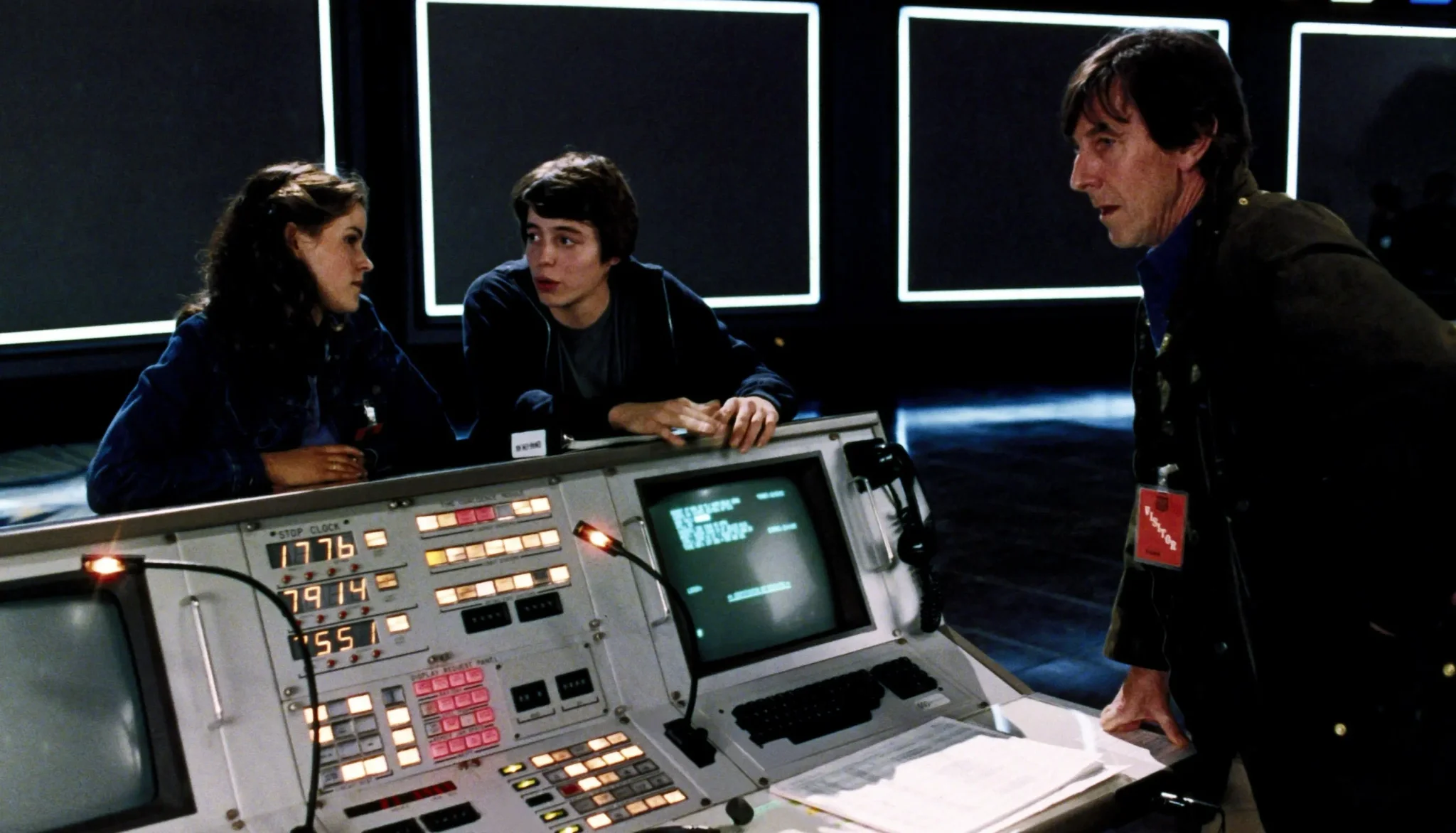 مشهد من فيلم "WarGames" يظهر مراهقين أمام حاسوب قديم يناقشون لعبة فيديو تحاكي حرباً نووية، يعكس مخاوف الذكاء الاصطناعي والدفاع الأمريكي.