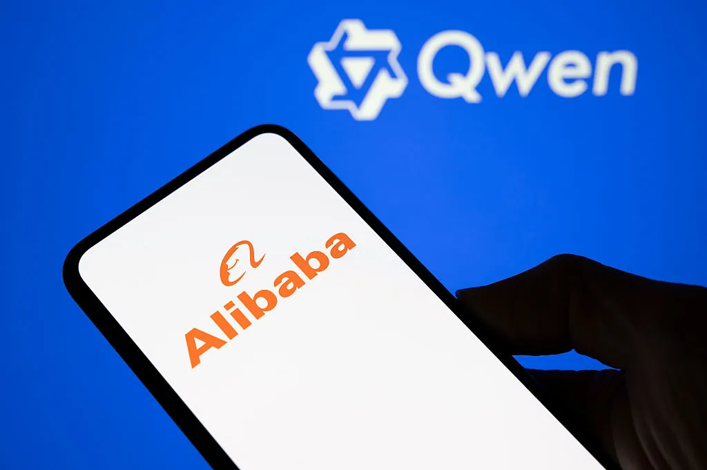شعار شركة Alibaba على هاتف ذكي أمام شعار نموذج الذكاء الاصطناعي Qwen على خلفية زرقاء، في سياق نقاش أمني وسياسي حول استخدام نموذج صيني في موقع حكومي أمريكي.