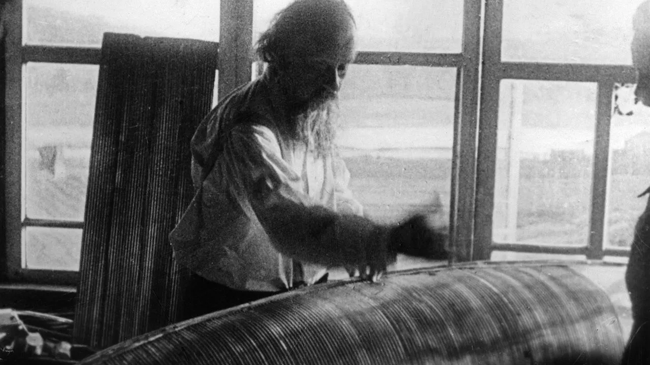 كونستانتين تسيولكوفسكي الروسي في ورشة عمله عام 1923، يعمل على نموذج أولي لمرايا فضائية لتركيز ضوء الشمس كمصدر للطاقة الشمسية الفضائية.